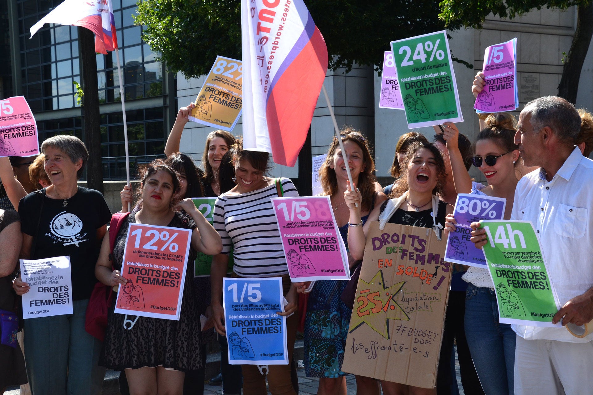 People holding signs against sexual harassment at work protest cuts to France's Ministry of Women's Rights budget, July 21, 2017.