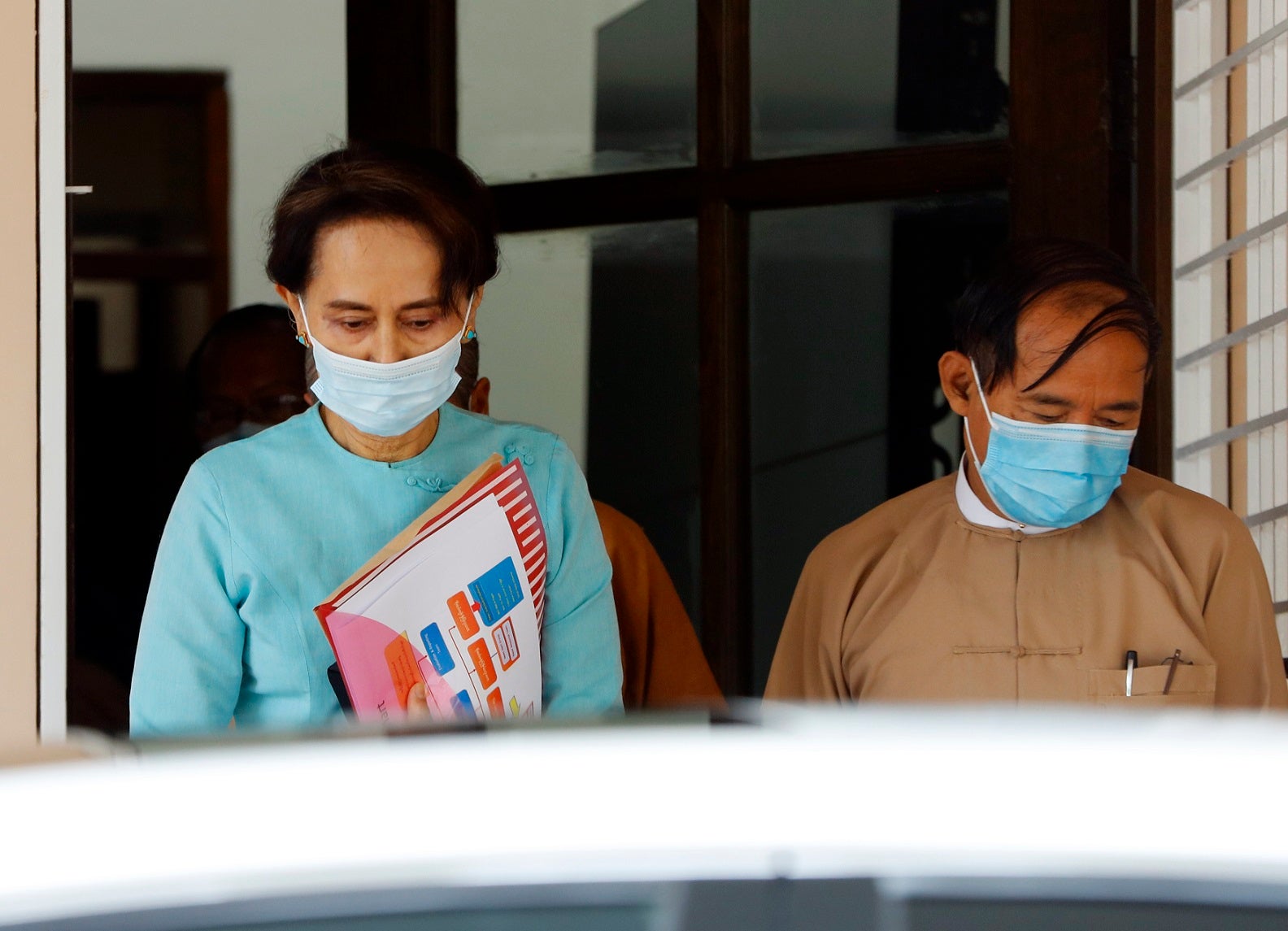 Myanmar leader Aung San Suu Kyi, left, and President Win Myint, wearing face masks to protect against the new coronavirus, leave after a Central Executive Committee meeting at their National League for Democracy (NLD) party headquarters in Naypyitaw, Myanmar Tuesday, July 21, 2020. 