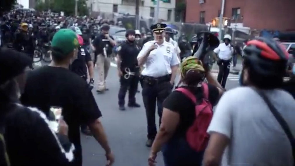 A uniformed police officer approaches a group of people