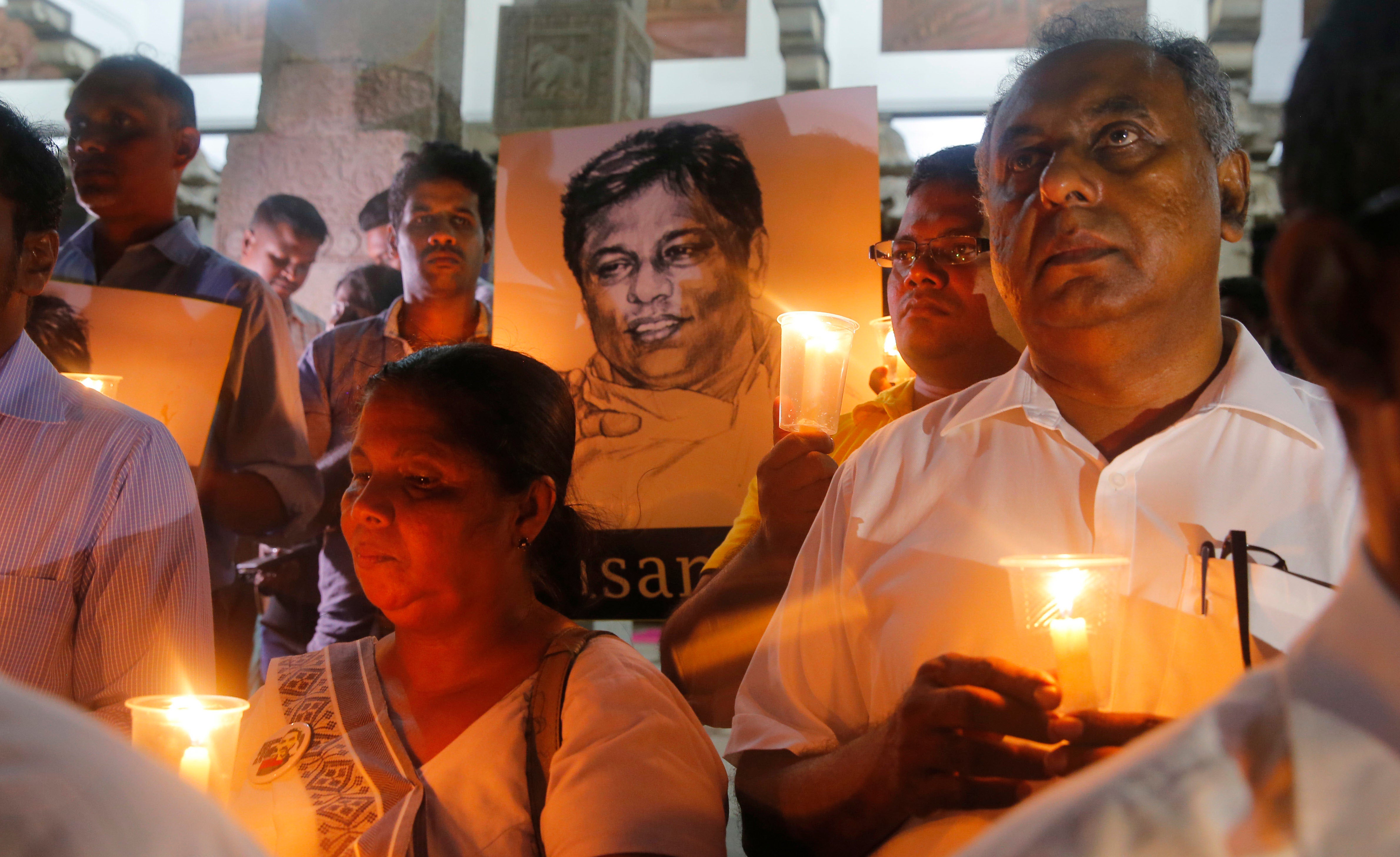 Men and women hold candles