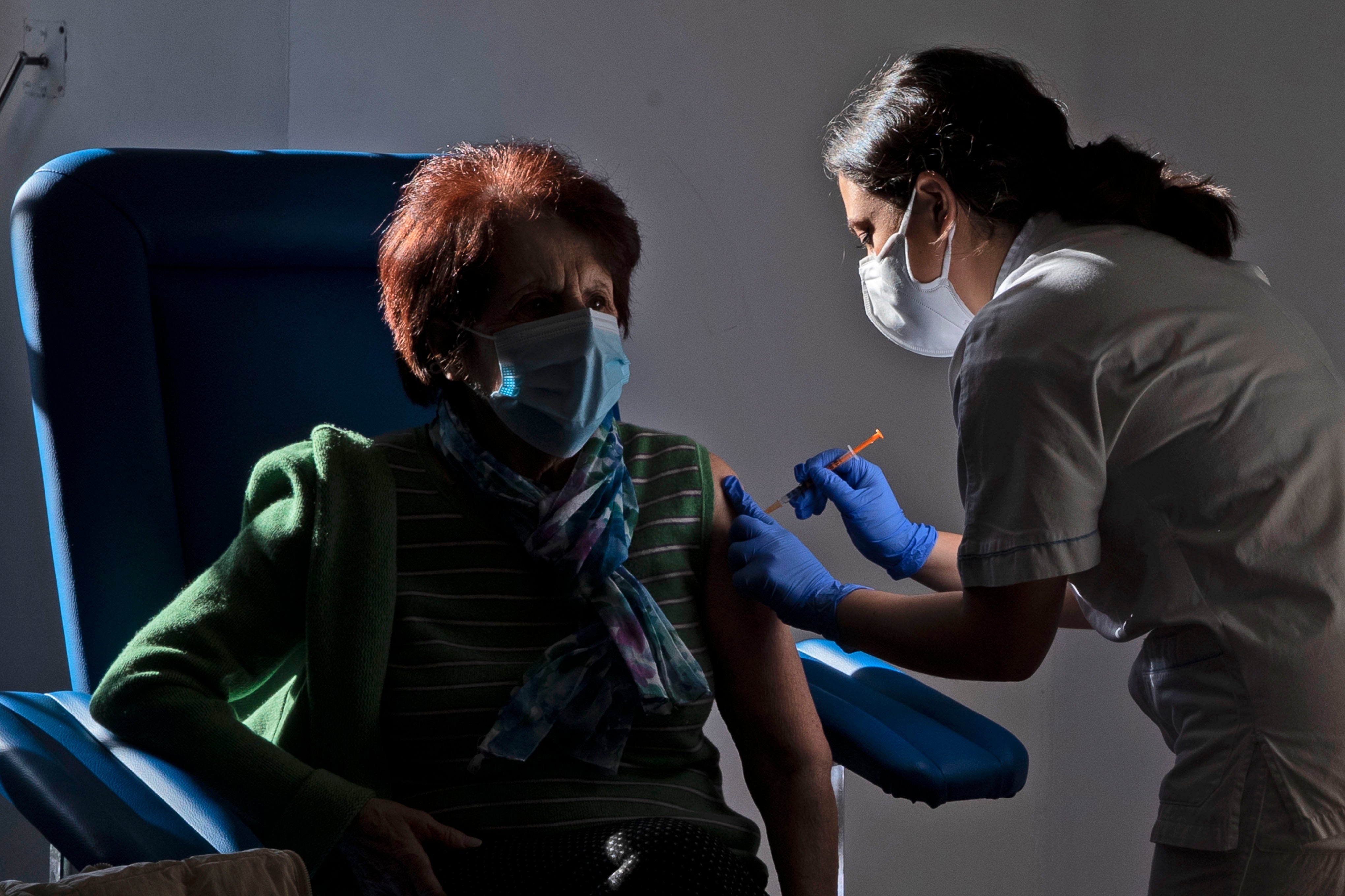 A medical staff member administers a dose of the Pfizer-Biotech vaccine to a person over eighty years old, in the Santa Maria della Pieta hospital in Rome, Italy.