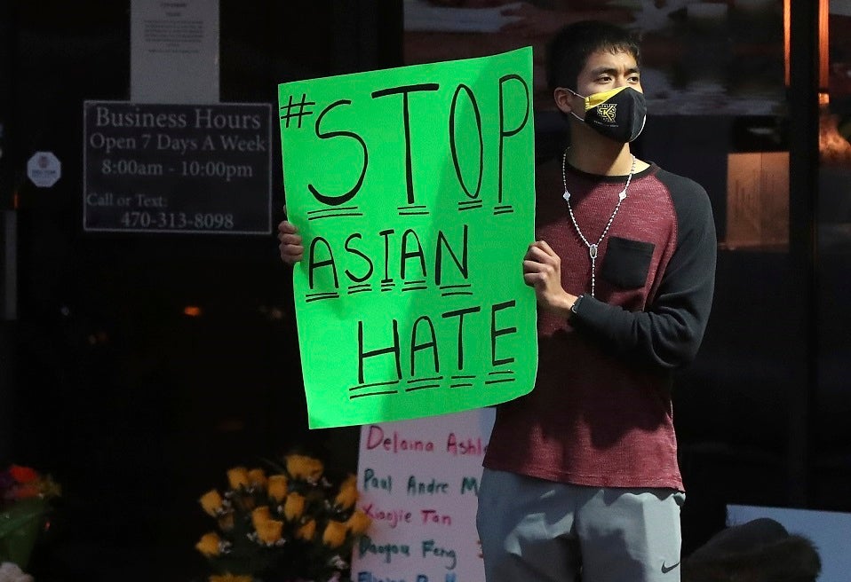 A man holds a sign reading “#StopAsianHate” outside Youngs Asian Massage in Acworth, Georgia on March 17, 2021, where four people were fatally shot the day before. 