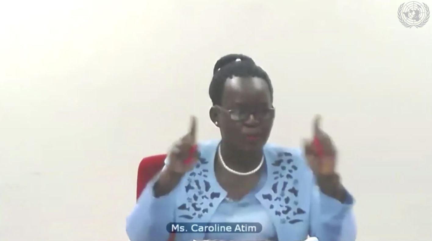 Caroline Atim, wearing a blue dress, addresses the United Nations Security Council during a virtual meeting, April 14, 2021. She is seated in front of a black background.