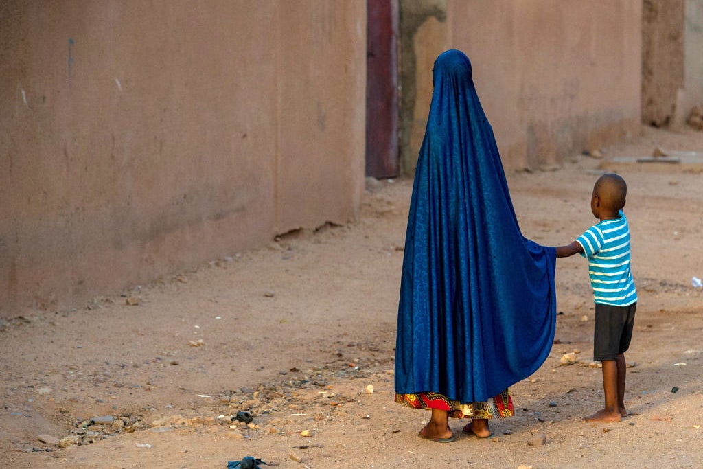 A girl holds the hand of a boy in Agadez, Niger on October 9, 2018.