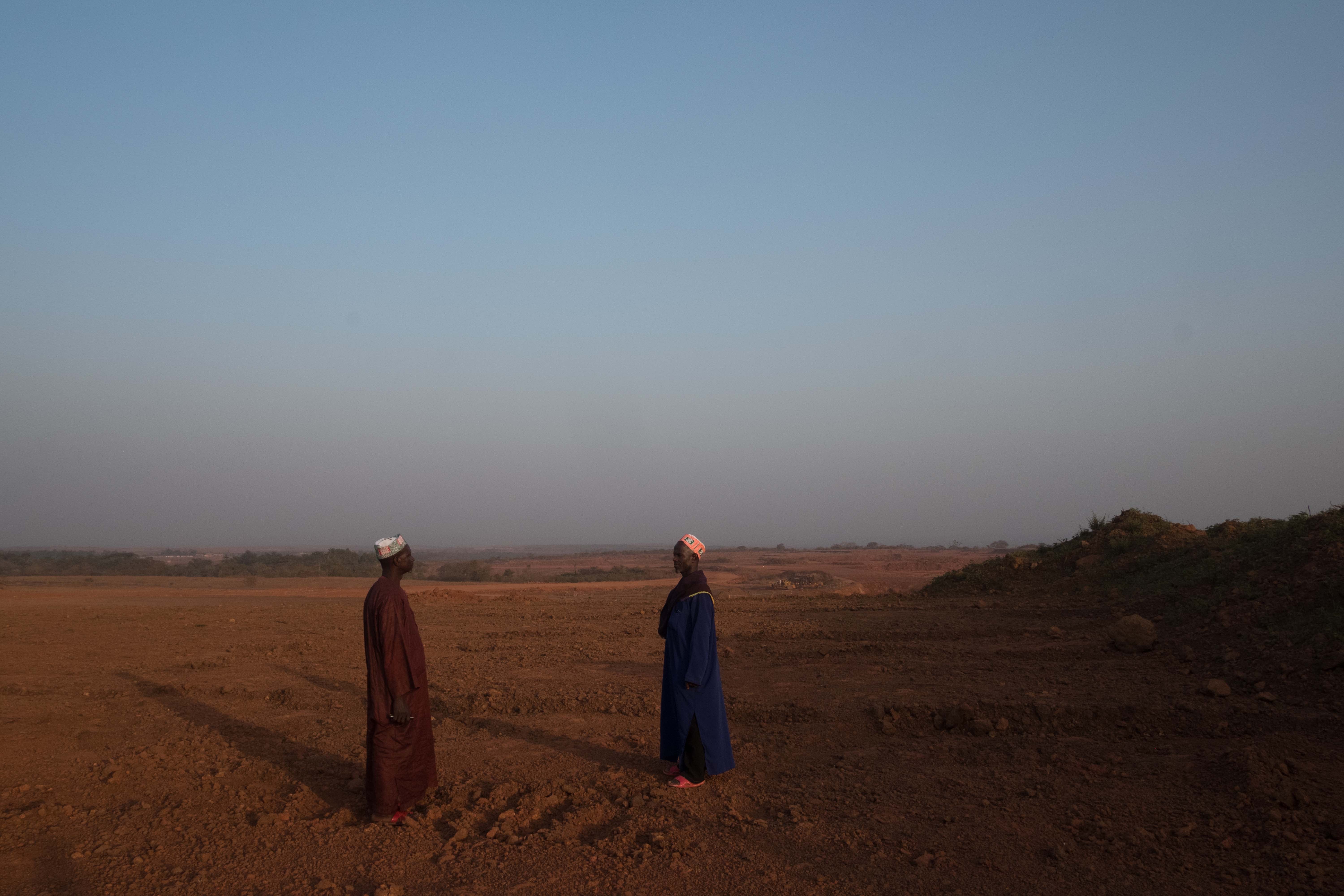 Two men standing in an empty field