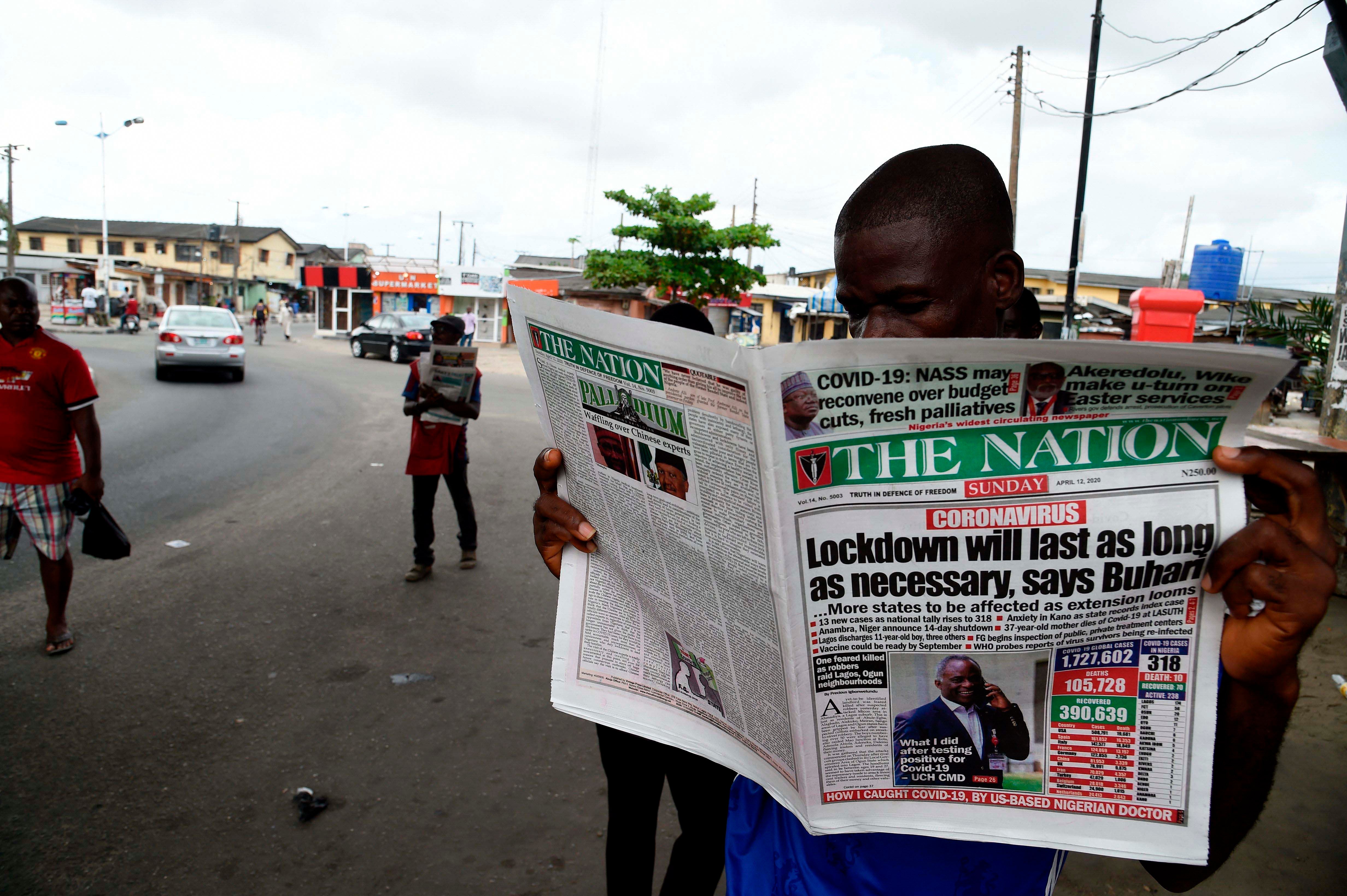 A man reading the newspaper "The Nation"