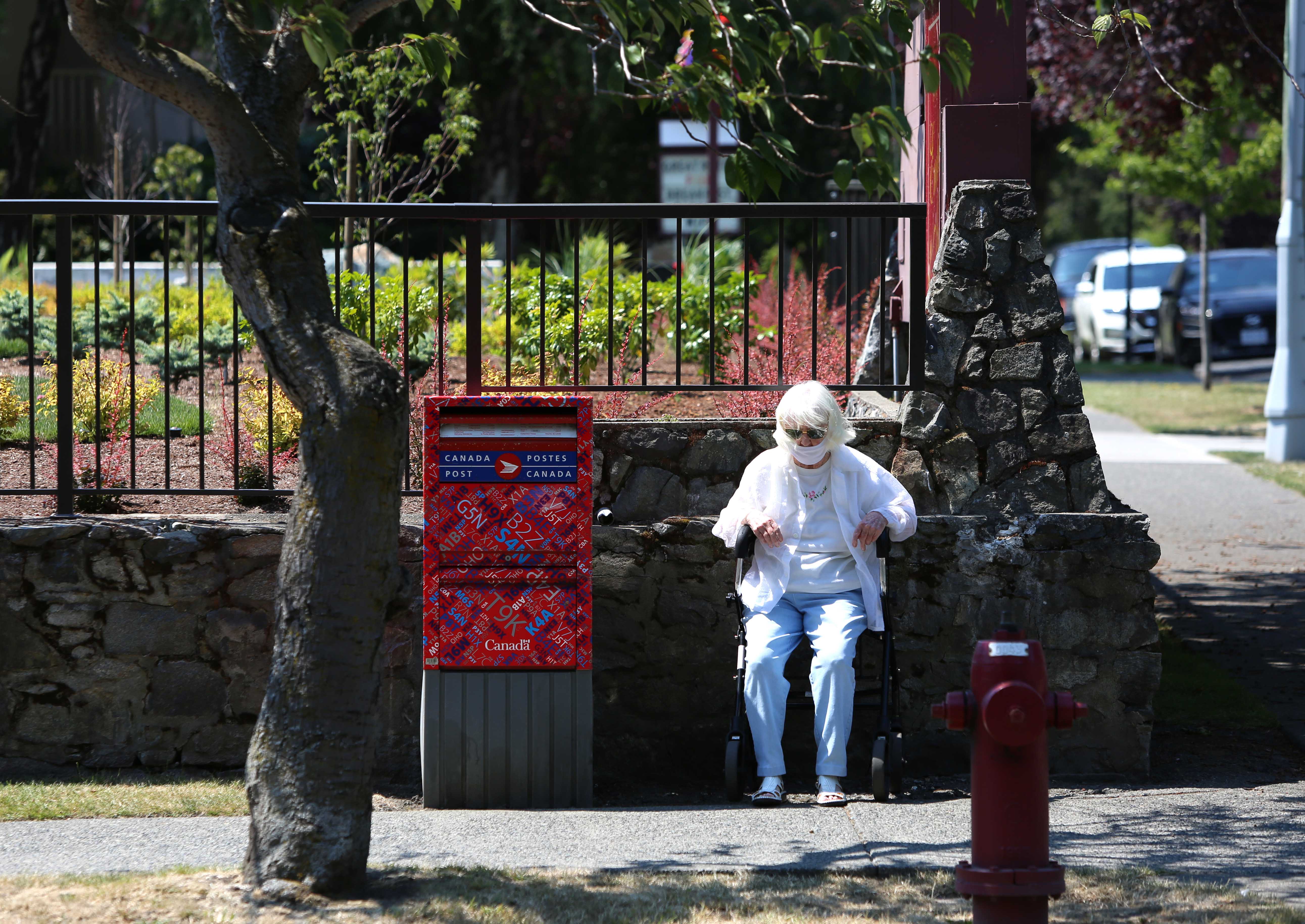 A woman sits to take a rest as heat wave hits Western Canada on June 30, 2021 in Victoria, British Columbia, Canada. © 2021 Mert Alper Dervis/Anadolu Agency via Getty Images