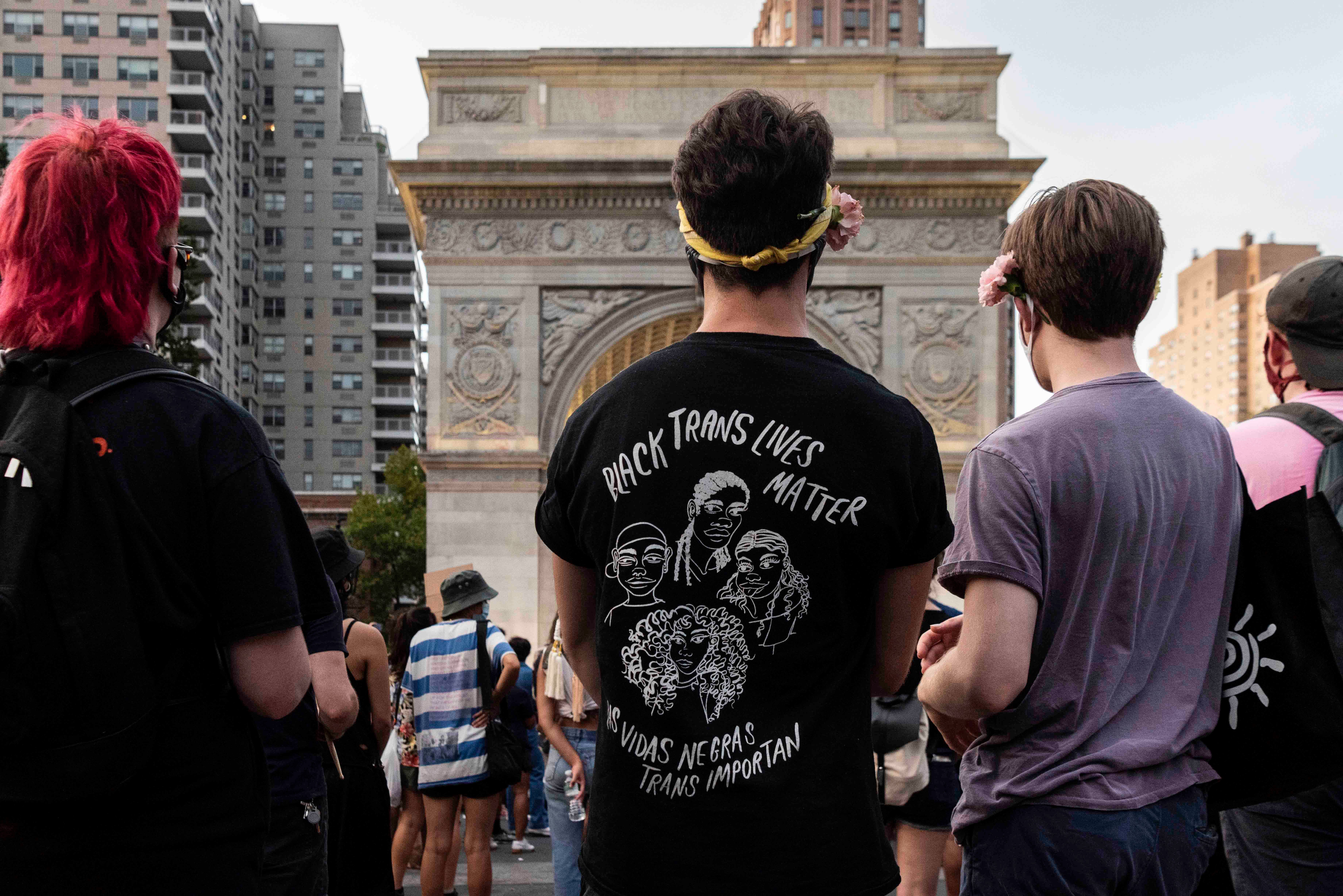 A person wearing a shirt that says "Black Trans Lives Matter (Las vidas negras trans importan)" at a rally