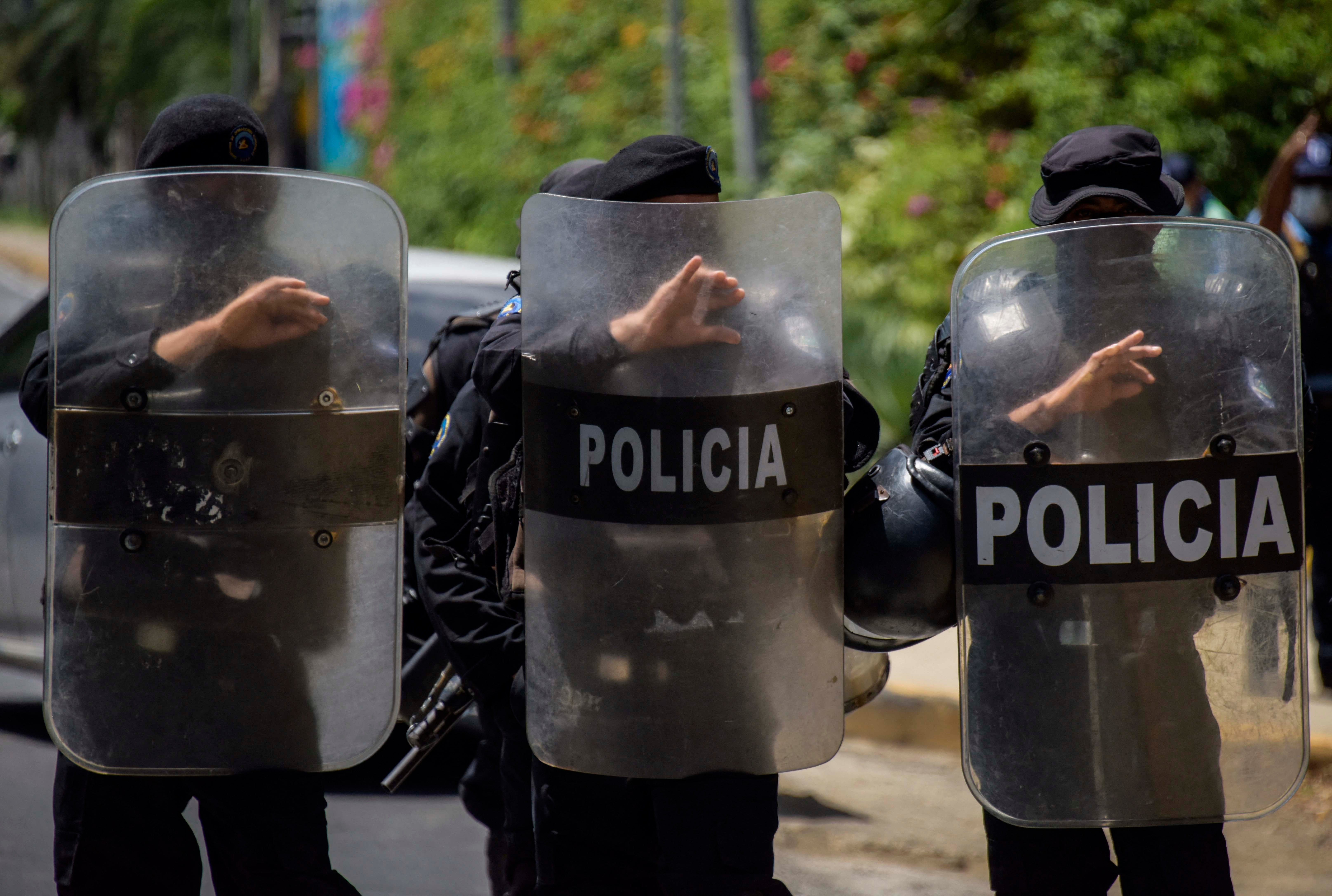 Riot police stand guard outside the house of Cristiana Chamorro, former director of the Violeta Barrios de Chamorro Foundation and opposition presidential candidate, in Managua on June 2, 2021, the day Nicaraguan police raided her home without a warrant and placed her under house arrest.