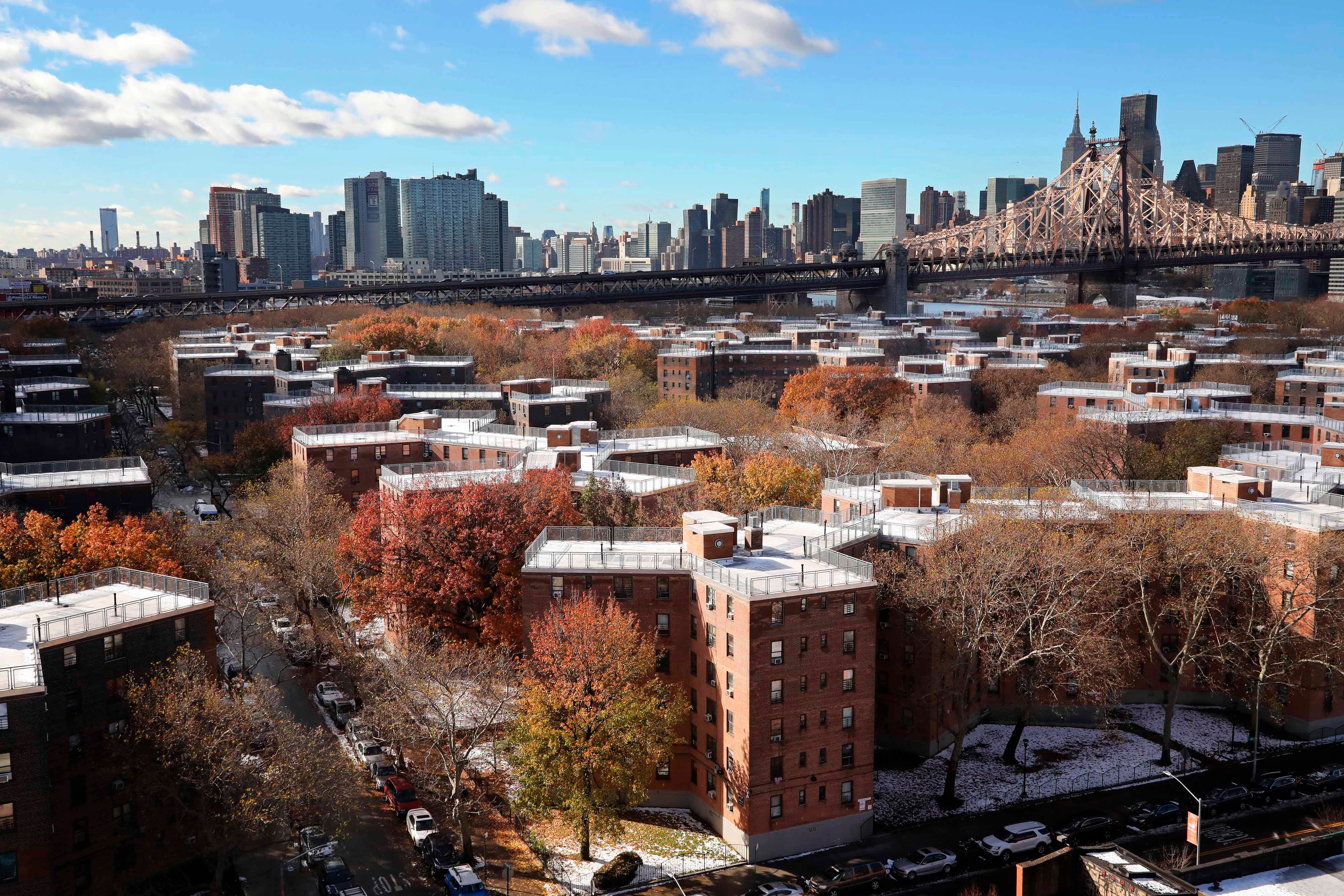 Aerial view of a housing complex with a city skyline behind it