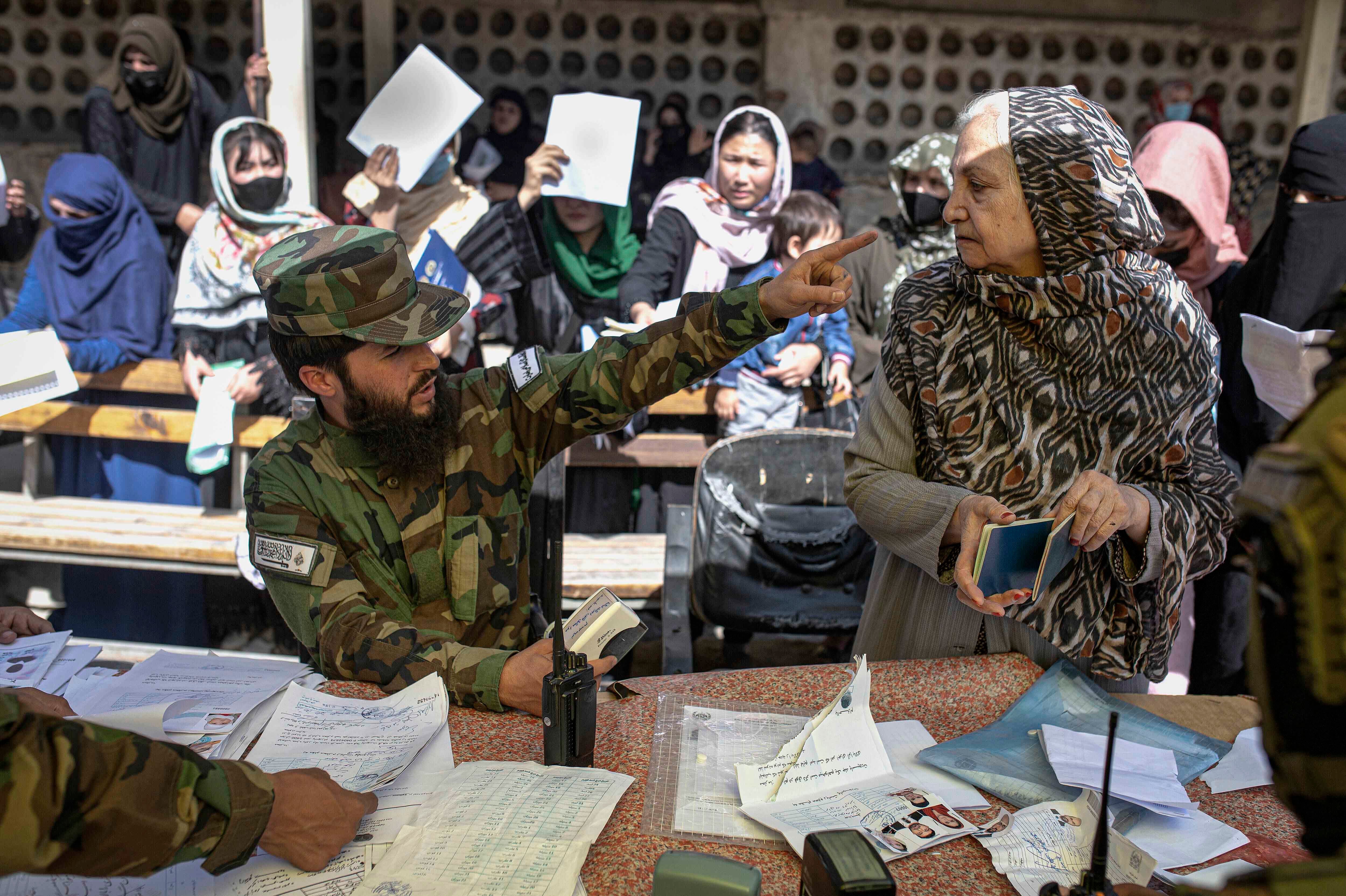 A man in military uniform points in the face of a woman 