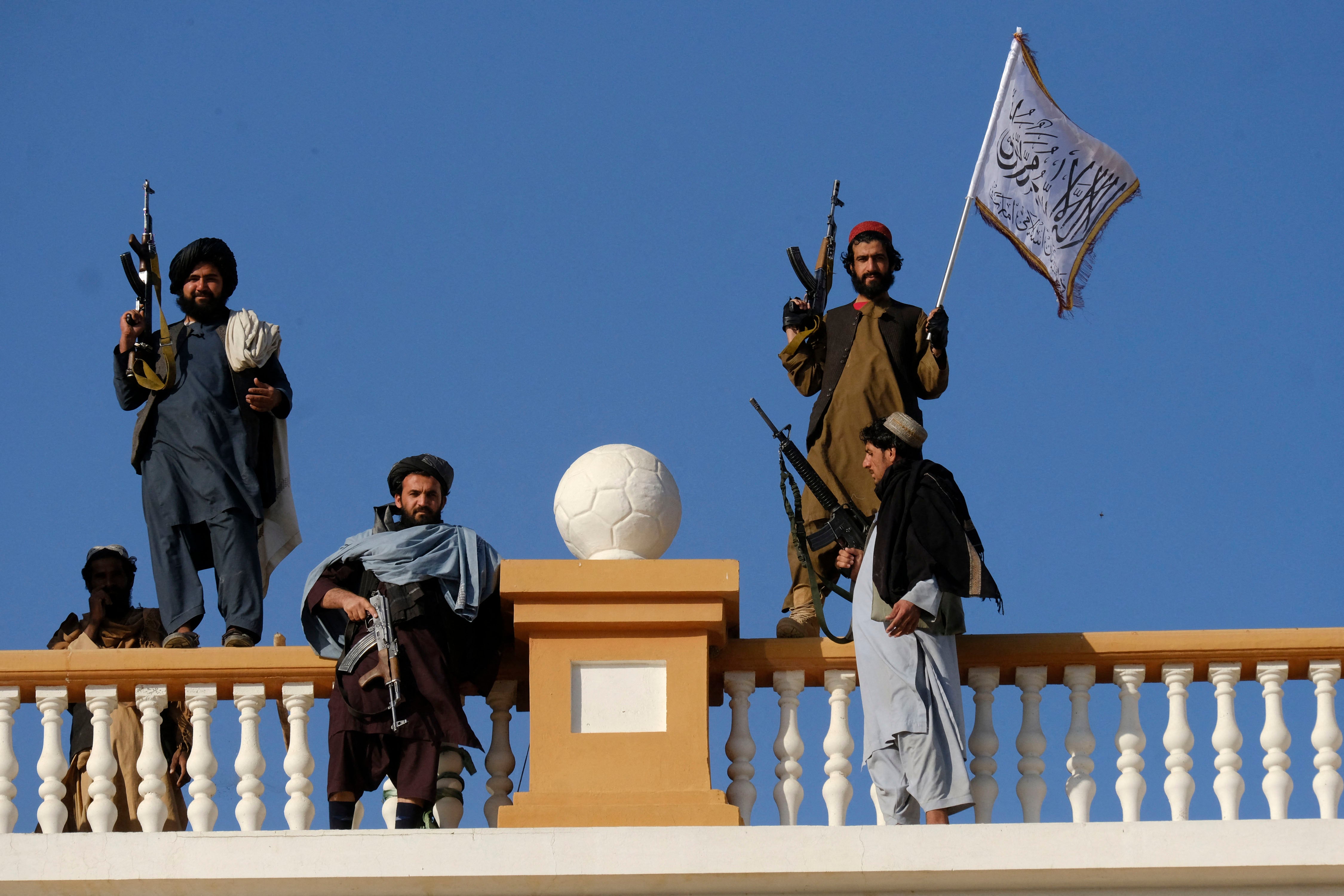 Armed men stand atop a city gate