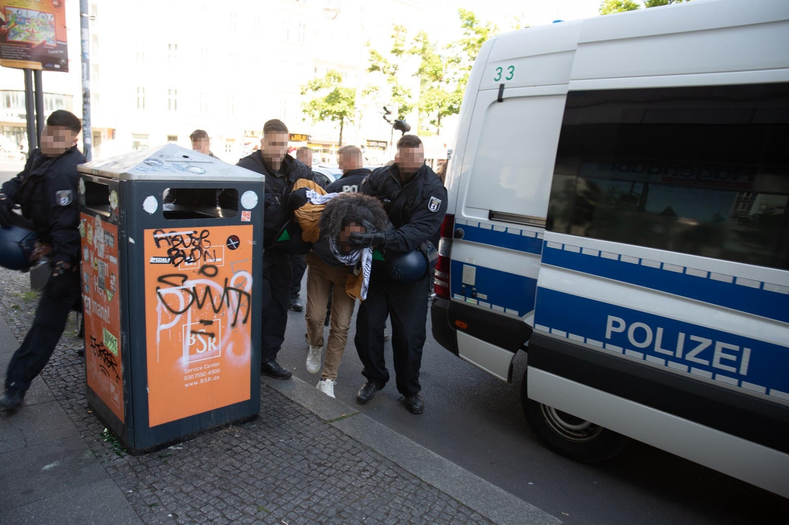 German police forcibly detain a man participating in a protest