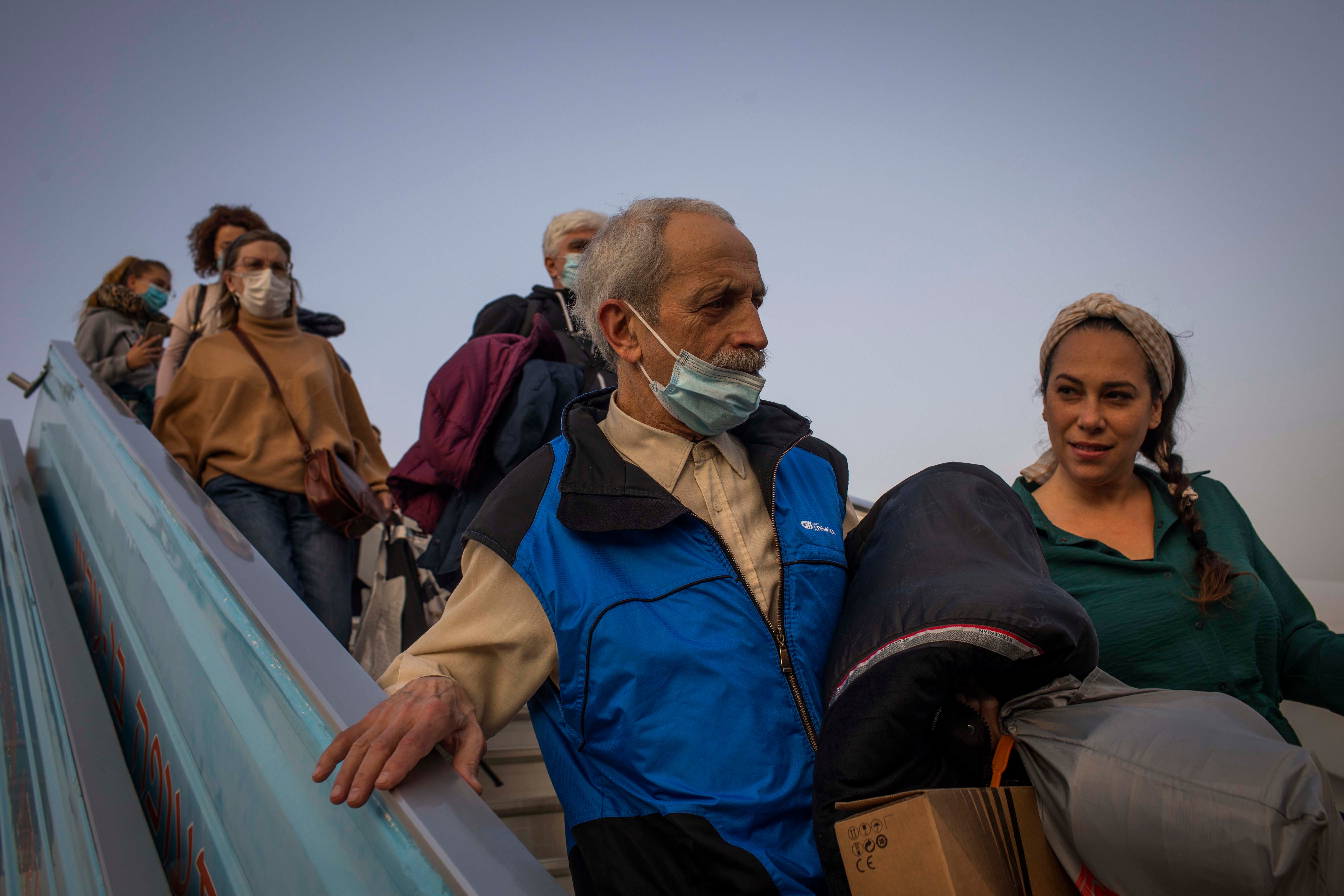 פליטים אוקראינים-יהודים יורדים מהמטוס בנמל התעופה בן גוריון בישראל ב-6 במארס 2022.