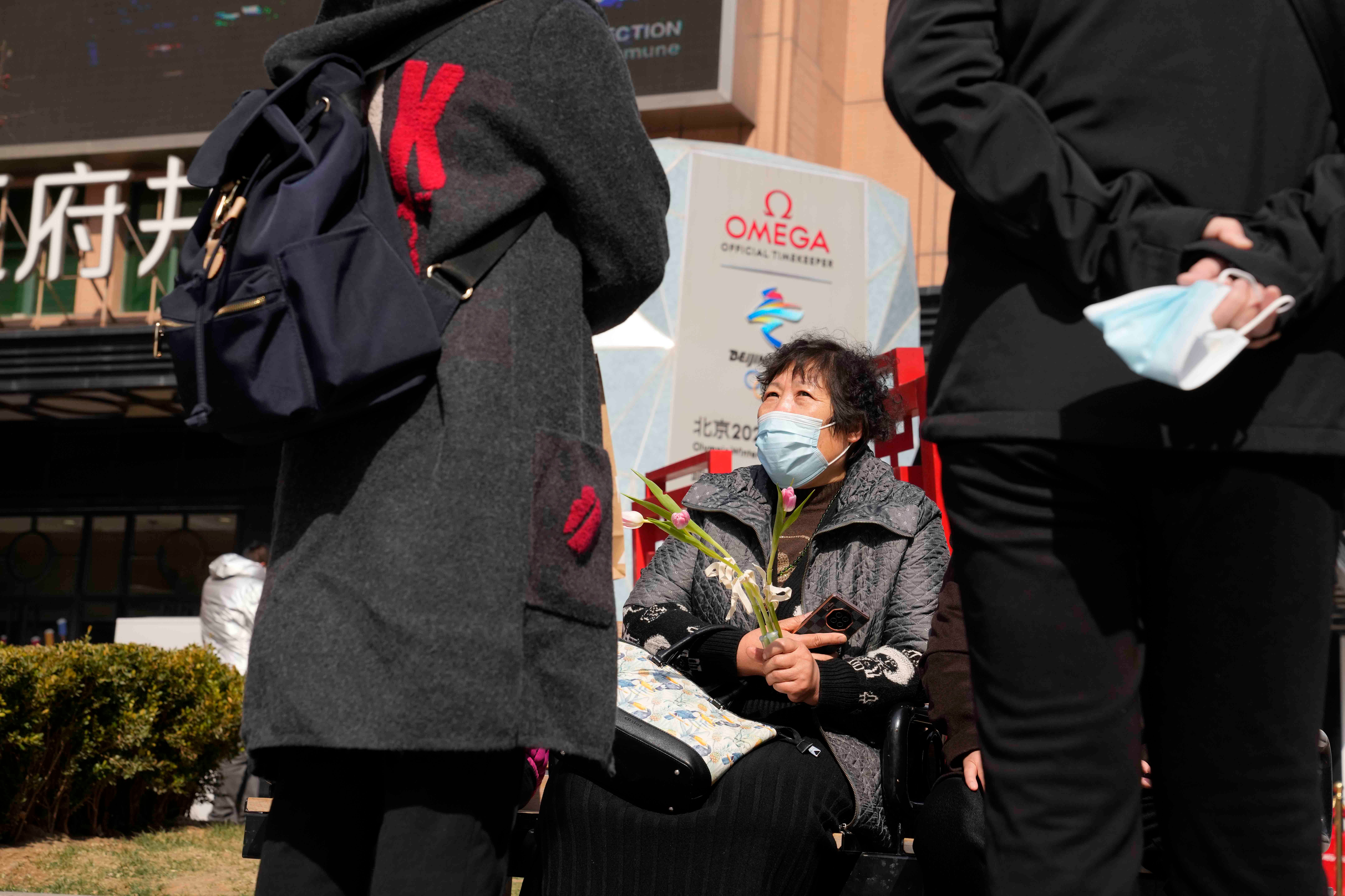 A woman holds flowers on International Women's Day on March 8, 2022, in Beijing.