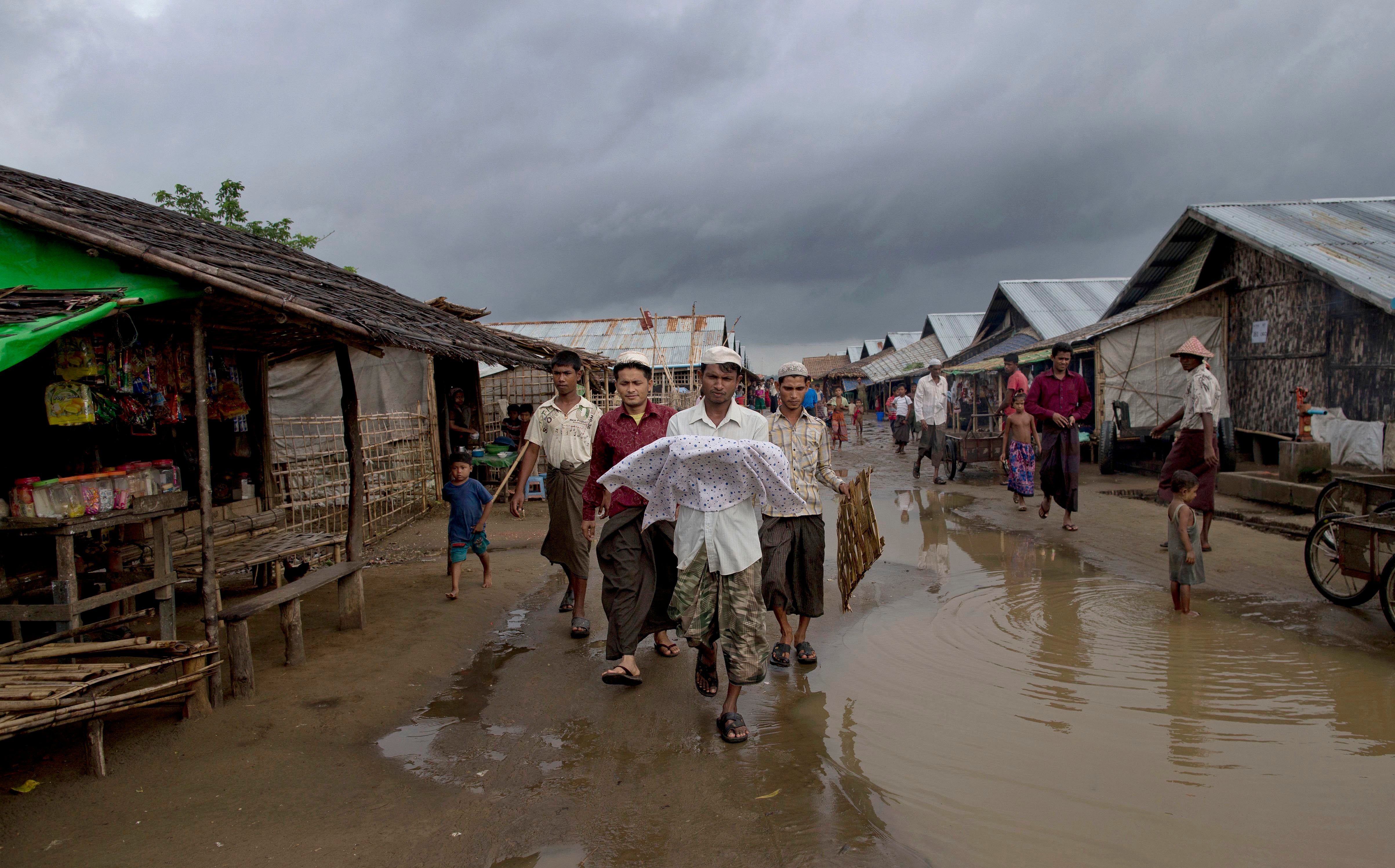 Cet homme rohingya portait le corps d’un bébé décédé ; c’était sa nièce, morte quelques heures seulement après sa naissance dans le camp de Dar Paing à Sittwe (État de Rakhine), dans l’ouest du Myanmar, le 27 juin 2014.