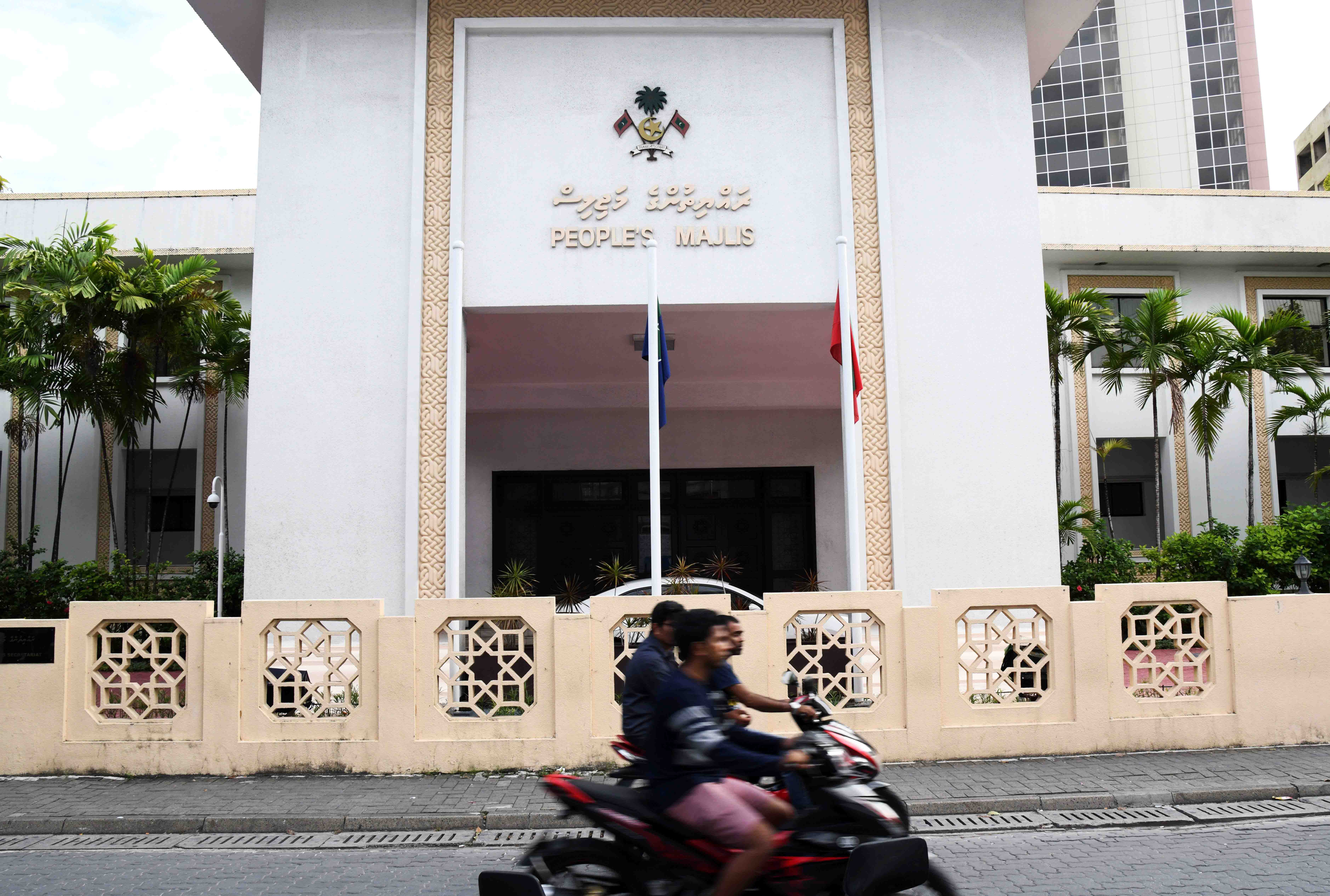 Motorists ride past the People's Majlis