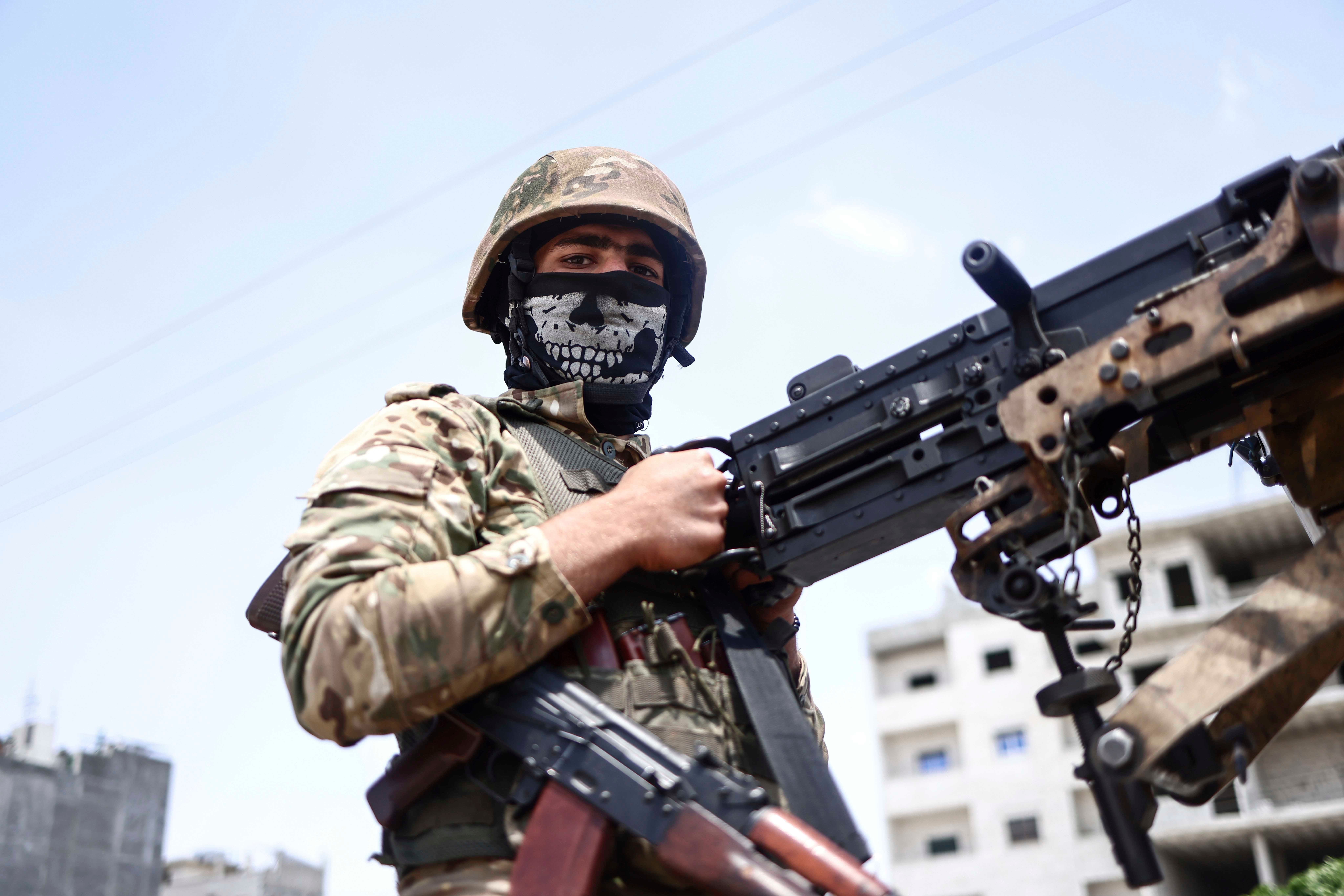 A fighter of the Turkish-backed Syrian National Army take part in a military parade in the countryside of Aleppo Governorate on June 9, 2022, as part of the forces' preparations for military actions on the areas controlled by the Syrian Democratic Forces.