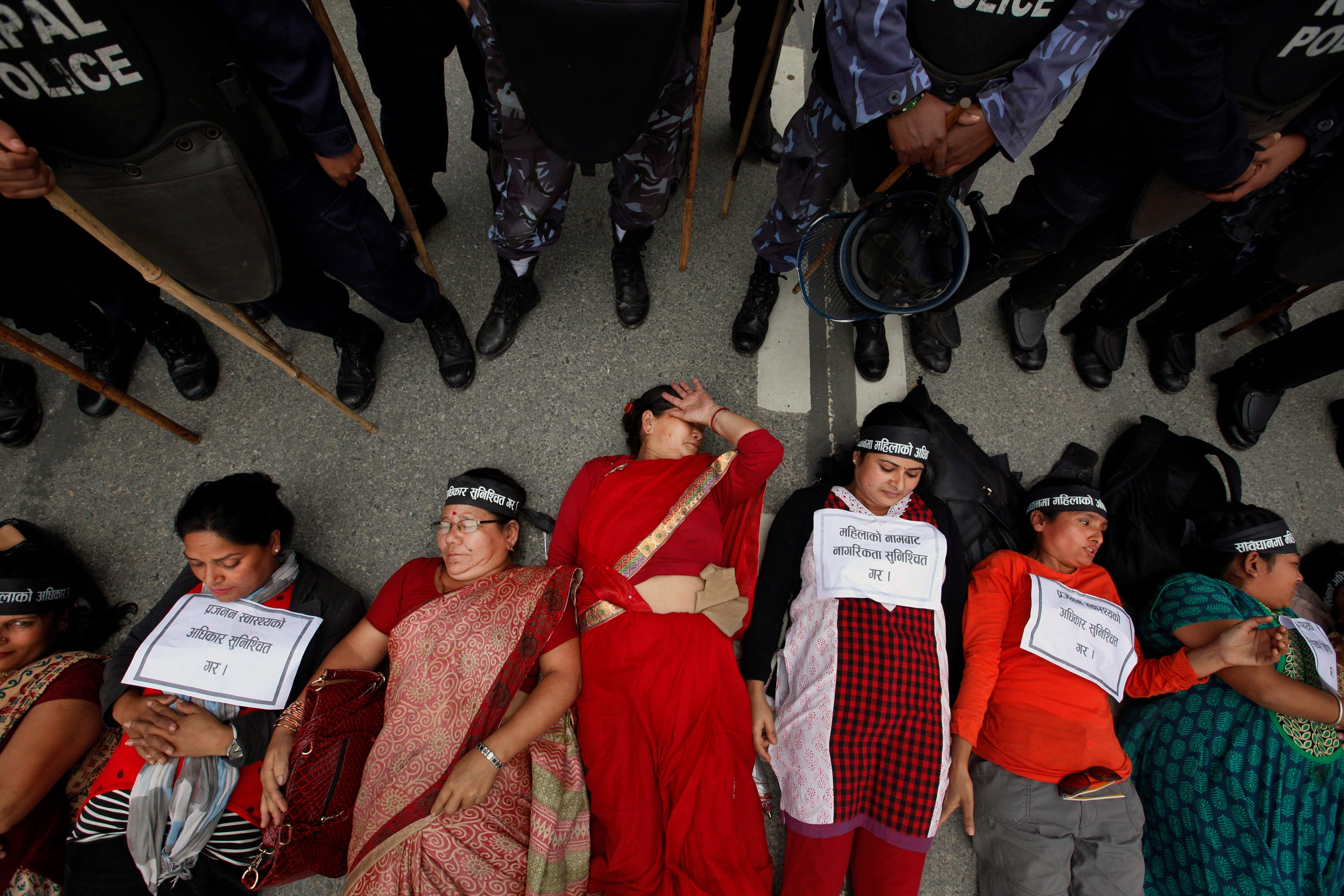 Nepalese women lie on the ground during a protest in Kathmandu