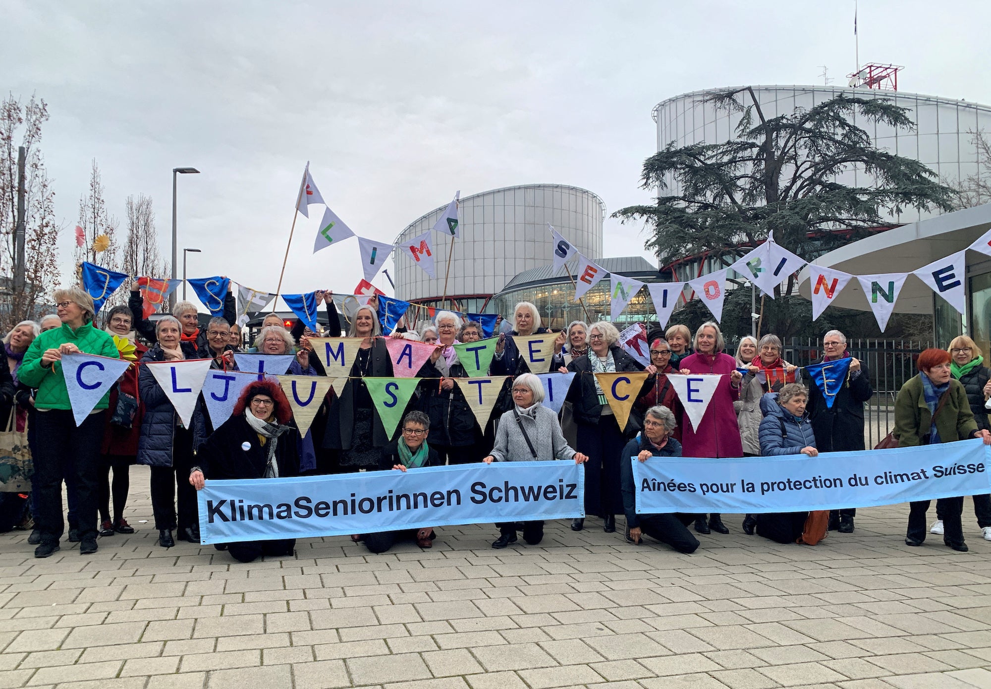 A group from the Senior Women for Climate Protection association hold banners outside the European Court of Human Rights in Strasbourg, France.