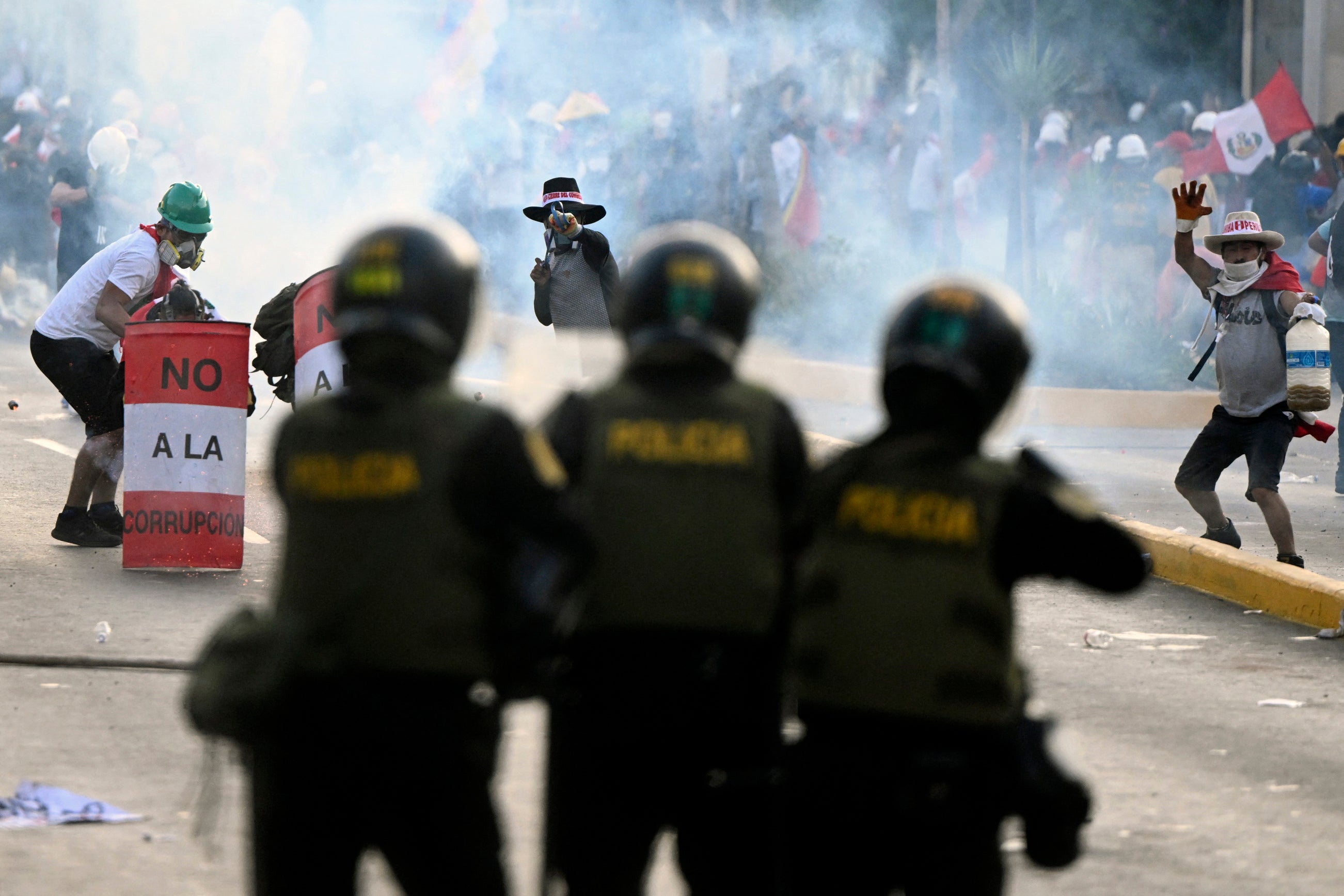 Demonstrators holding shields throw rocks at police