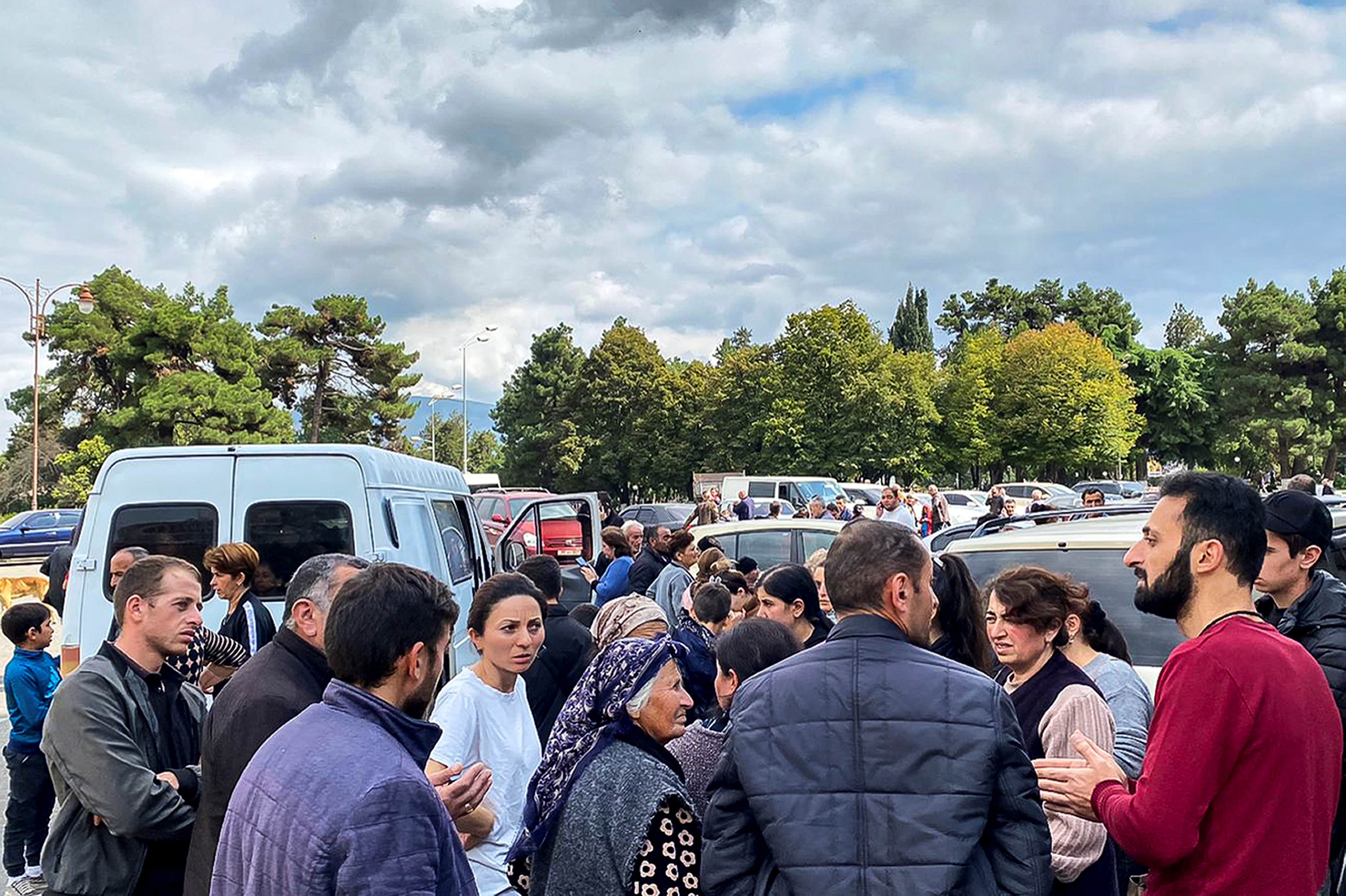 A local government worker, right in red, tries to reassure residents during shooting in the vicinity, in Stepanakert/Khankendi, Nagorno-Karabakh on September 21, 2023. 