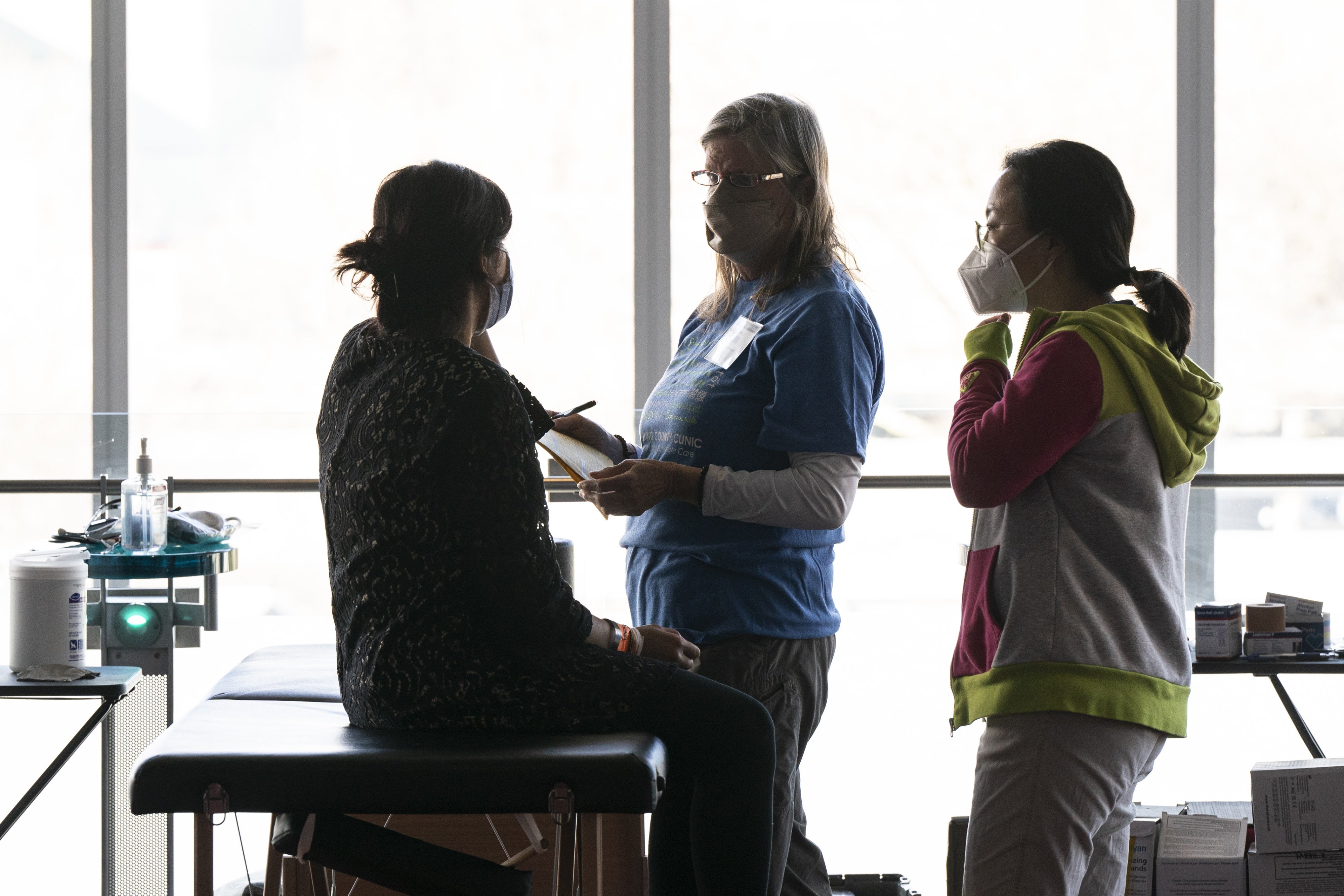 Volunteers offer free physical therapy services for a patient at the Seattle/King County Clinic, during an annual free healthcare event held at Seattle Center on February 16, 2024.