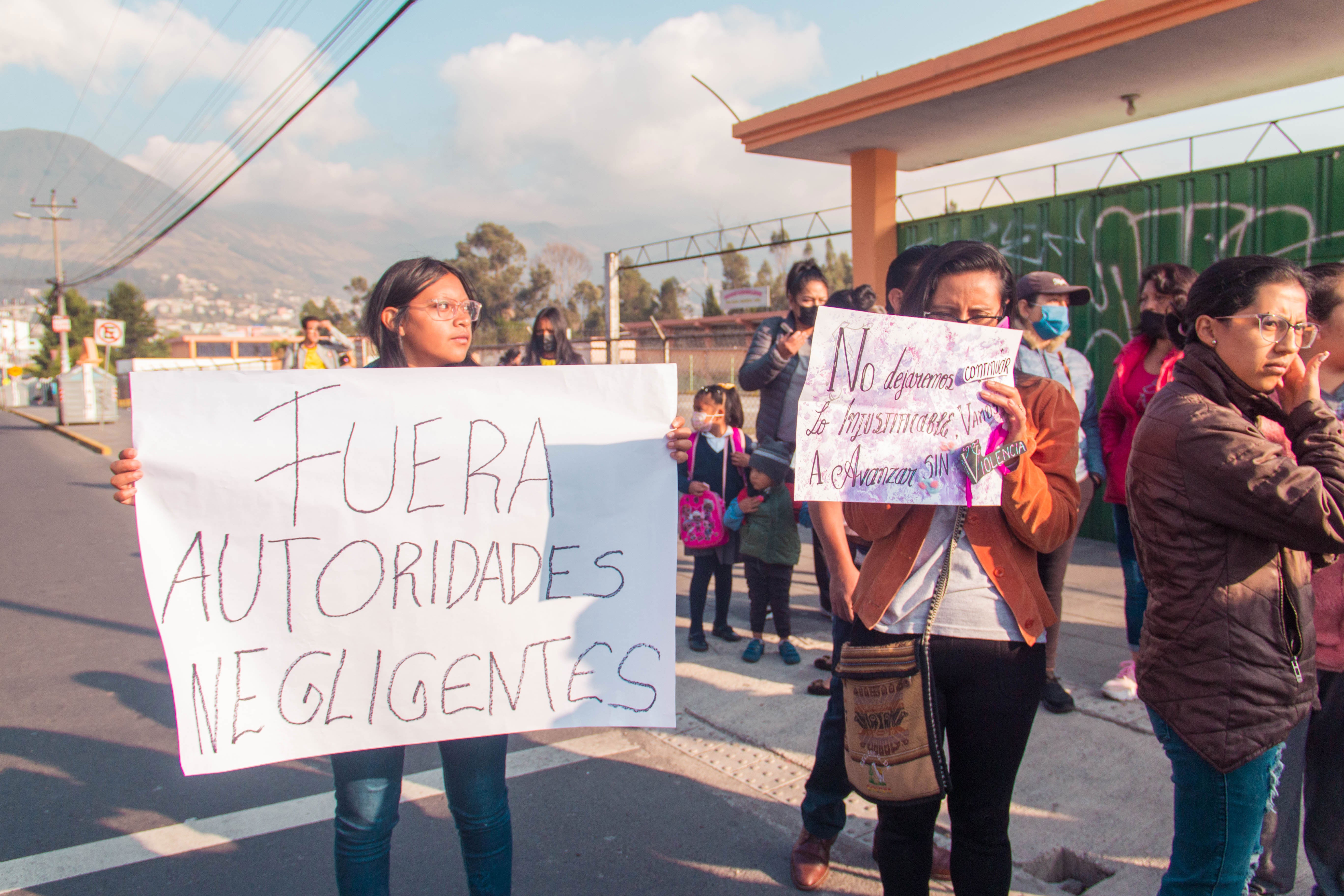 Women hold banners in Spanish at a protest