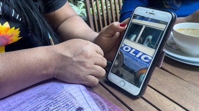 A woman displays a video on her phone