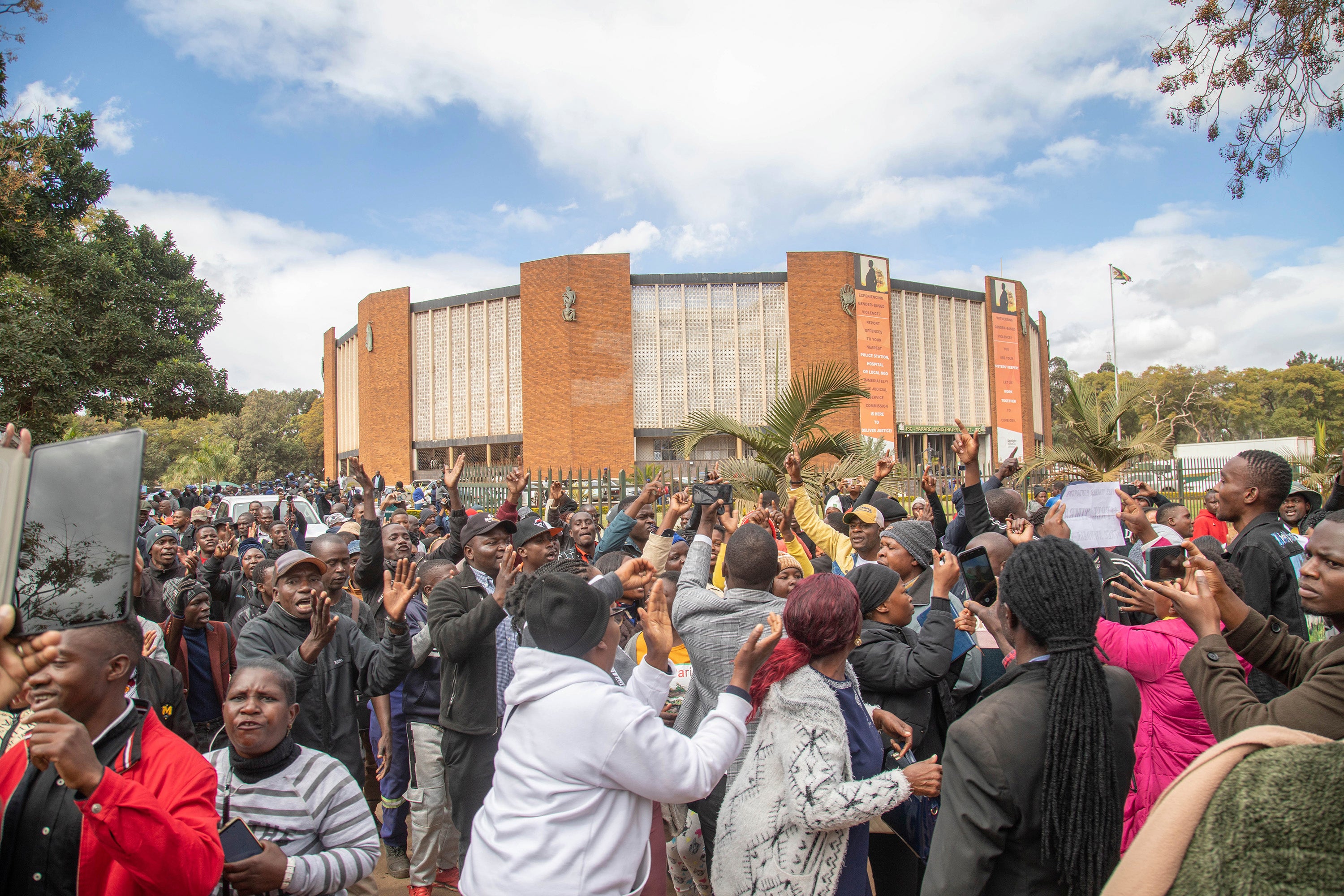 Opposition supporters protest outside a court, in Harare, Zimbabwe