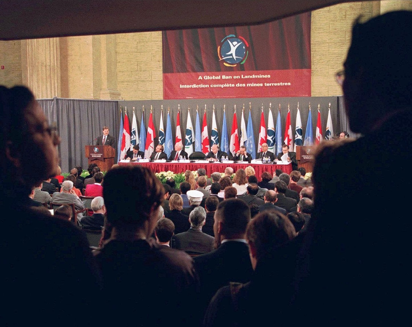 Le ministre canadien des Affaires étrangères Lloyd Axworthy, debout à gauche, prononçait un discours lors de la signature de la Convention sur l'interdiction des mines antipersonnel à Ottawa, au Canada, le 2 décembre 1997.