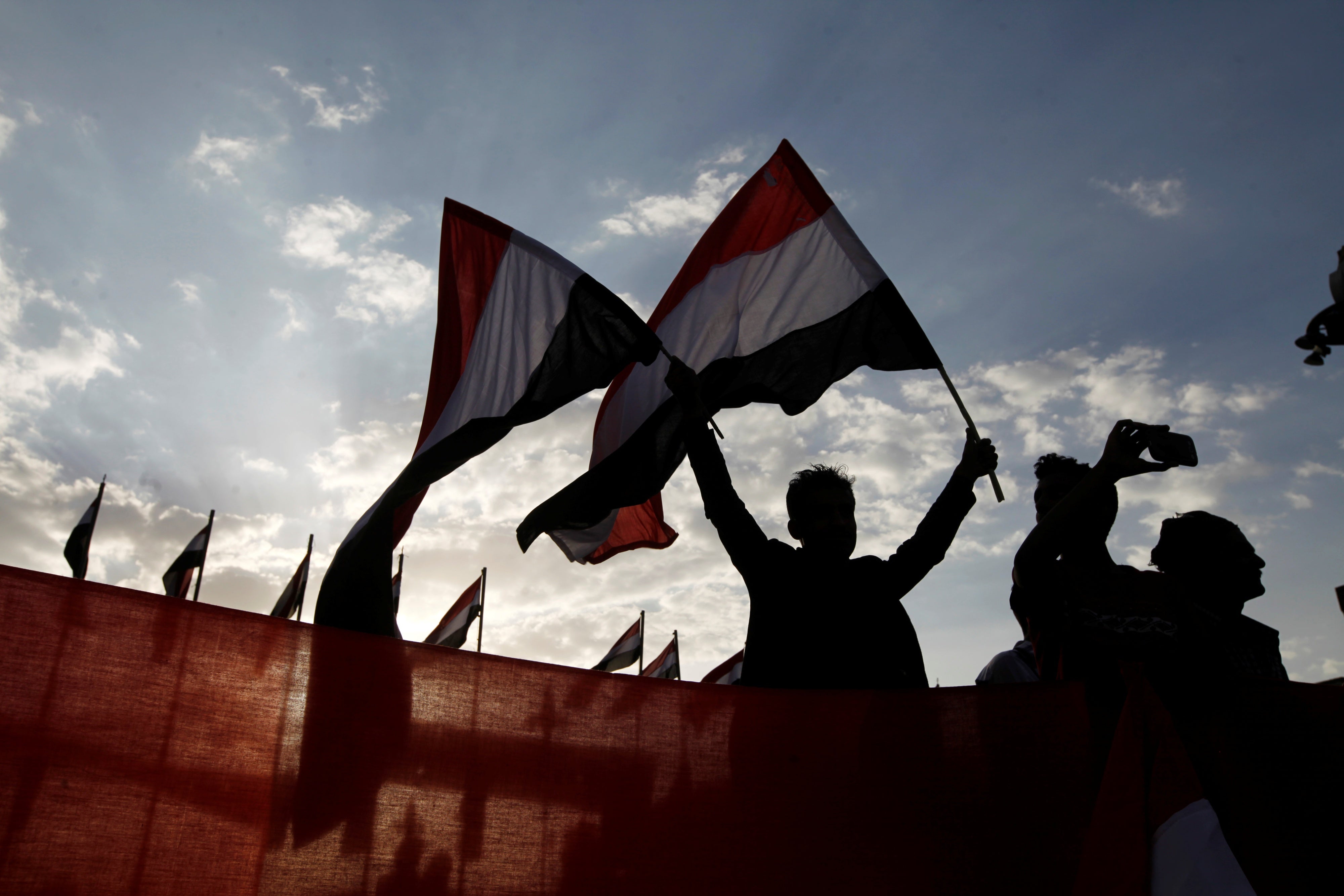 A person waves Yemeni flags during a ceremony marking the anniversary of the September 1962 revolution in Sanaa, Yemen.