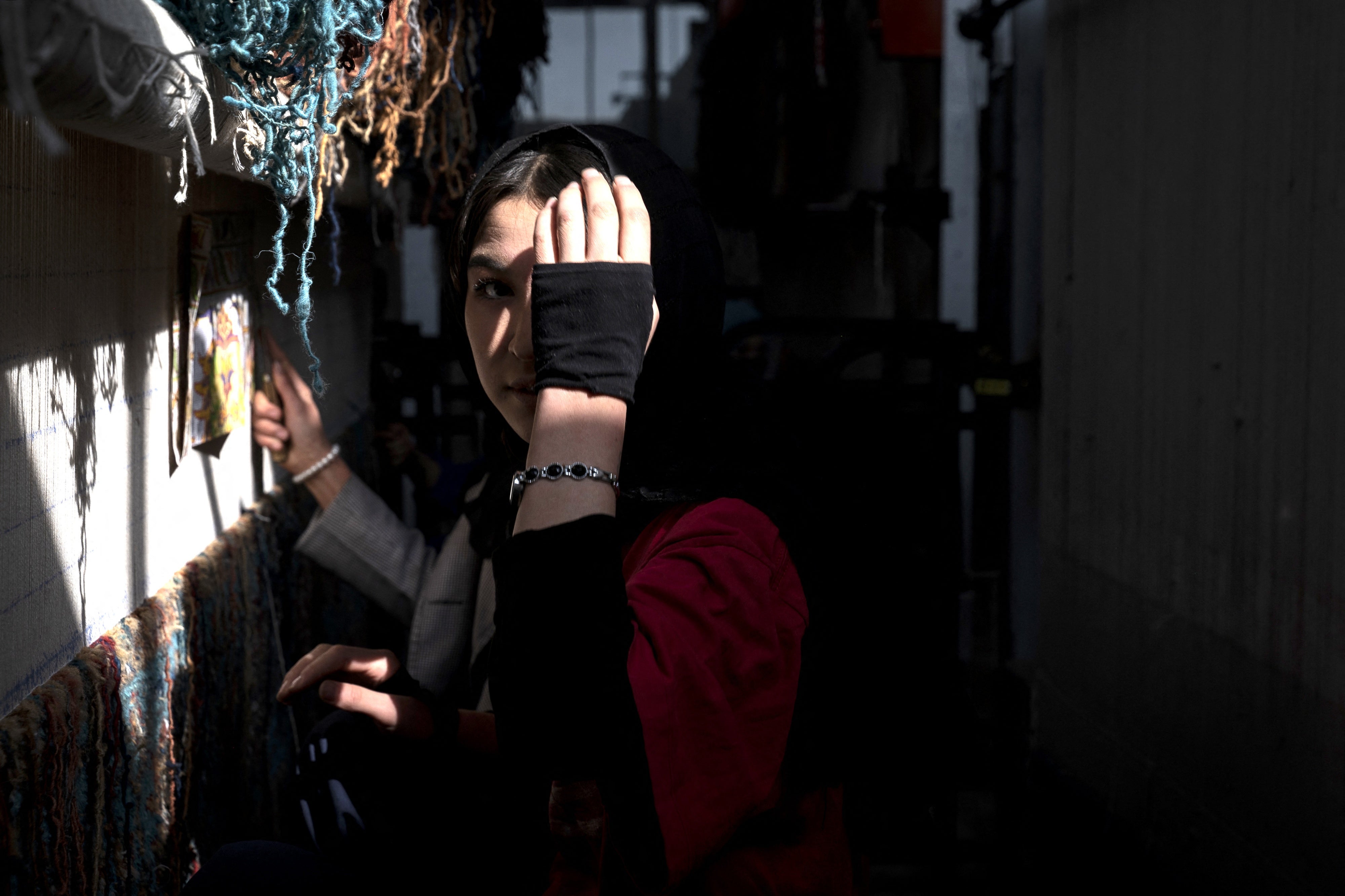An Afghan woman weaves a carpet at a factory on the outskirts of Kabul, Afghanistan, November 11, 2024.