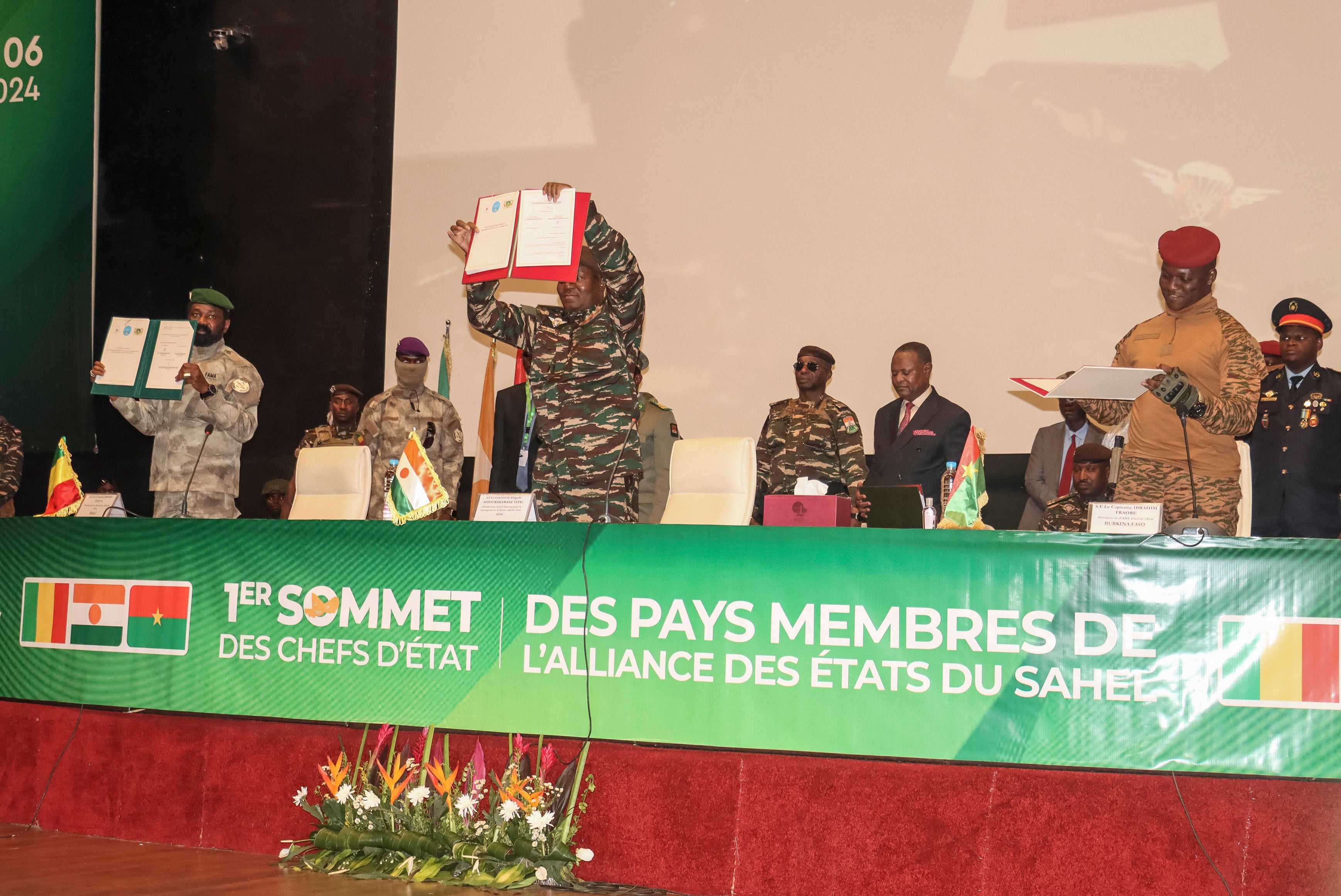 Les dirigeants du Niger, le général Abdourahamane Tiani (au centre), du Mali, le colonel Assimi Goïta (à gauche), et du Burkina Faso, le capitaine Ibrahim Traoré (à droite), montrent les documents de l'Alliance des États du Sahel qu'ils ont signé lors de leur première réunion à Niamey, au Niger, le 6 juillet 2024.