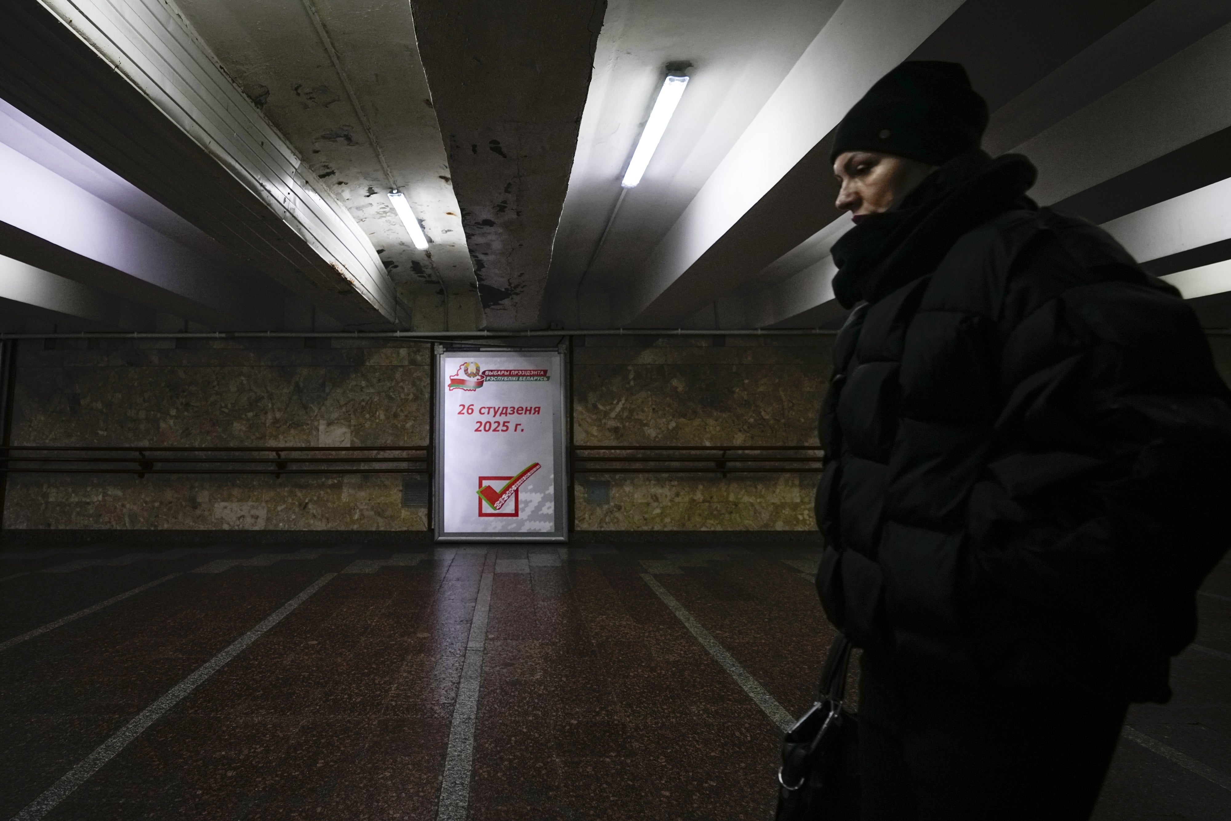 A woman walks past an election poster
