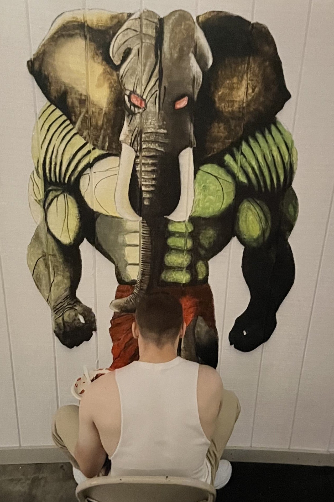 A youth paints a mural on a wall