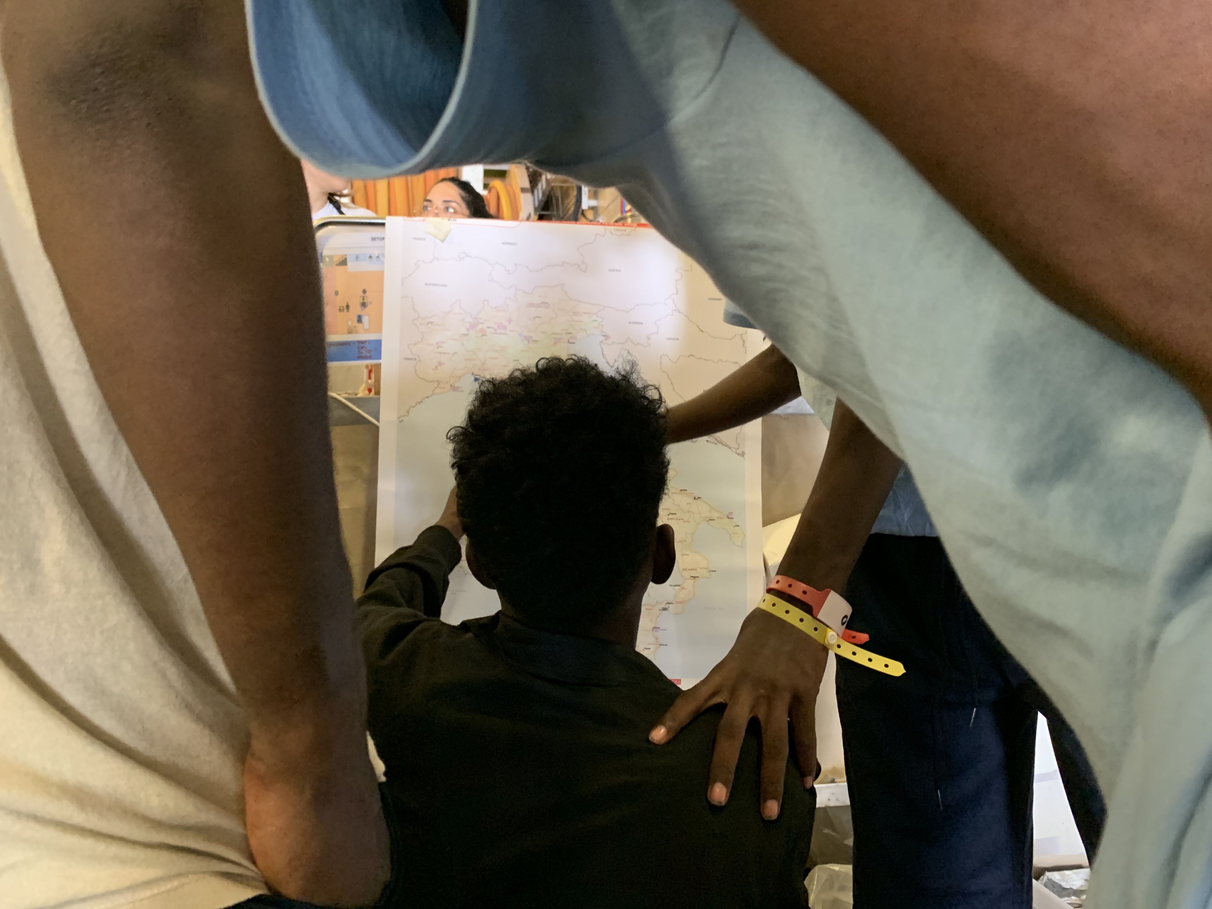 Survivors on the Geo Barents look at a map of Italy, September 20, 2024. 