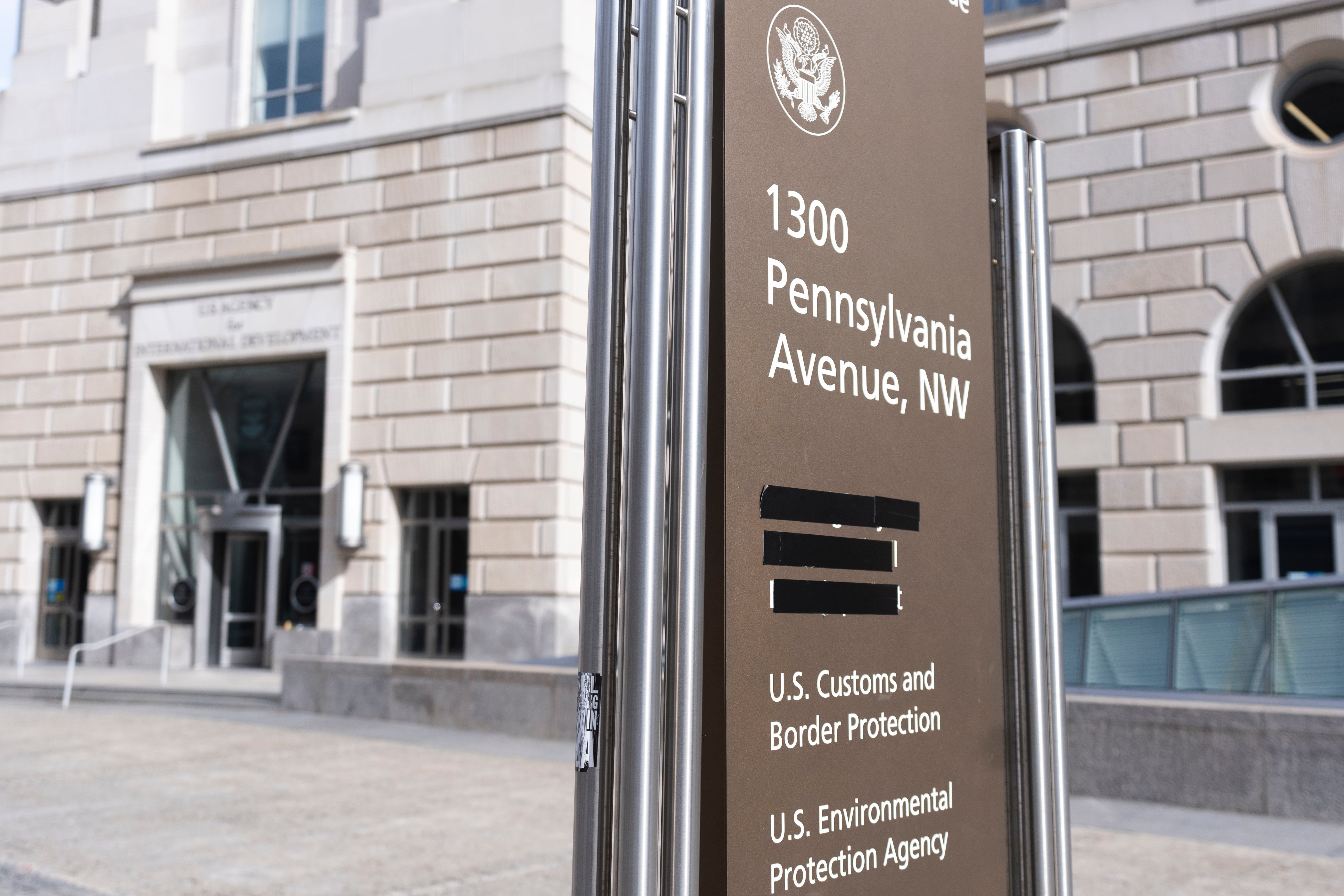 A sign with the names of US government agencies housed at the Ronald Reagan Building in Washington, DC, with the USAID headquarters taped over, February 7, 2025. 