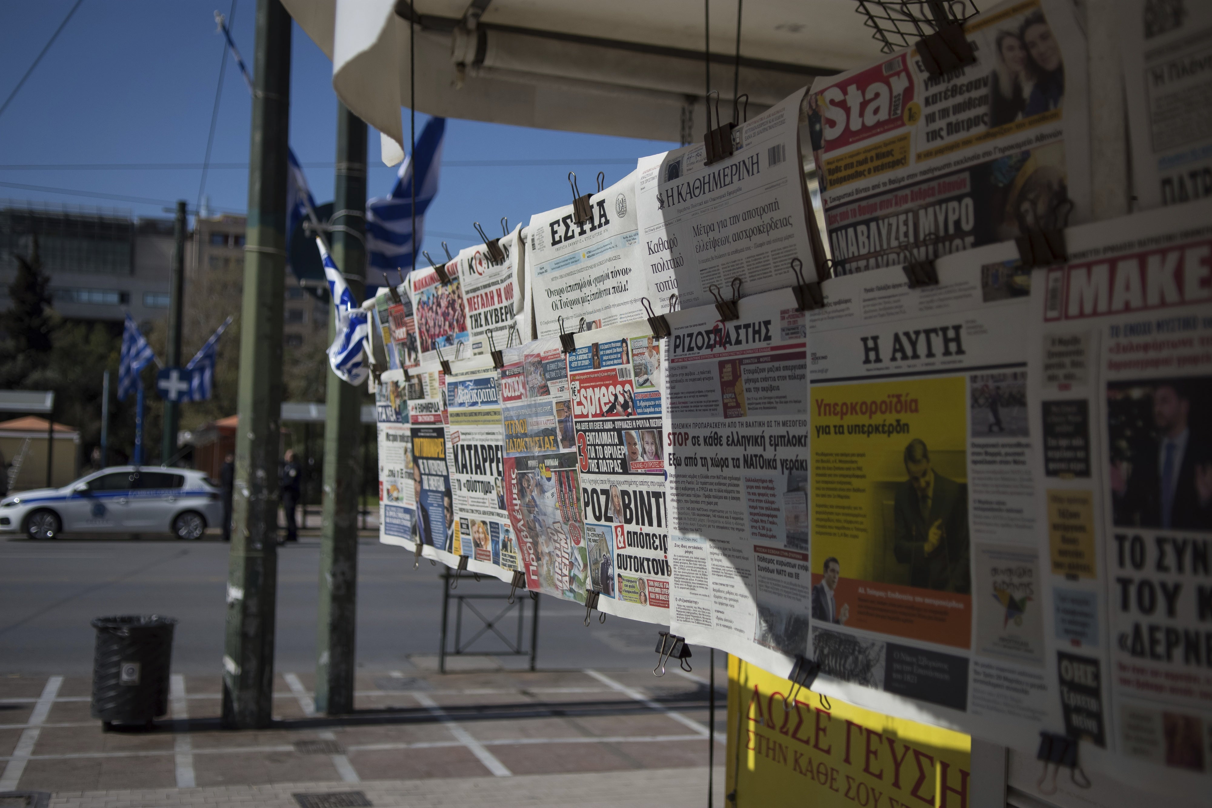 Plusieurs journaux grecs et internationaux accrochés à l’extérieur d’un kiosque à journaux dans le centre d'Athènes, en Grèce, le 24 mars 2022. 