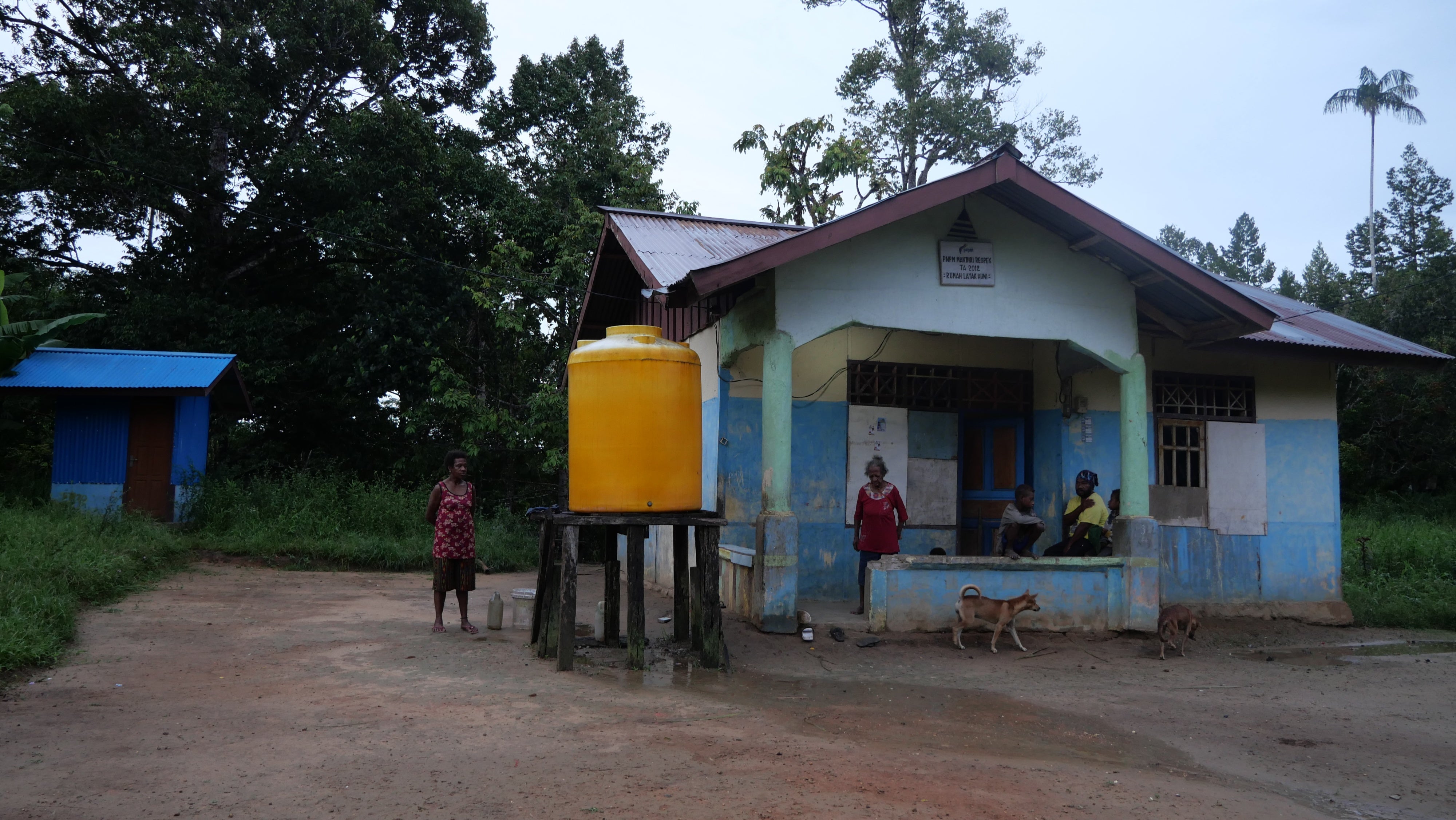 Imelda Maa and her daughter Laurensia Yame, along with other family members, outside their house in Ampera village, Mandobo district, Boven Digoel Regency.