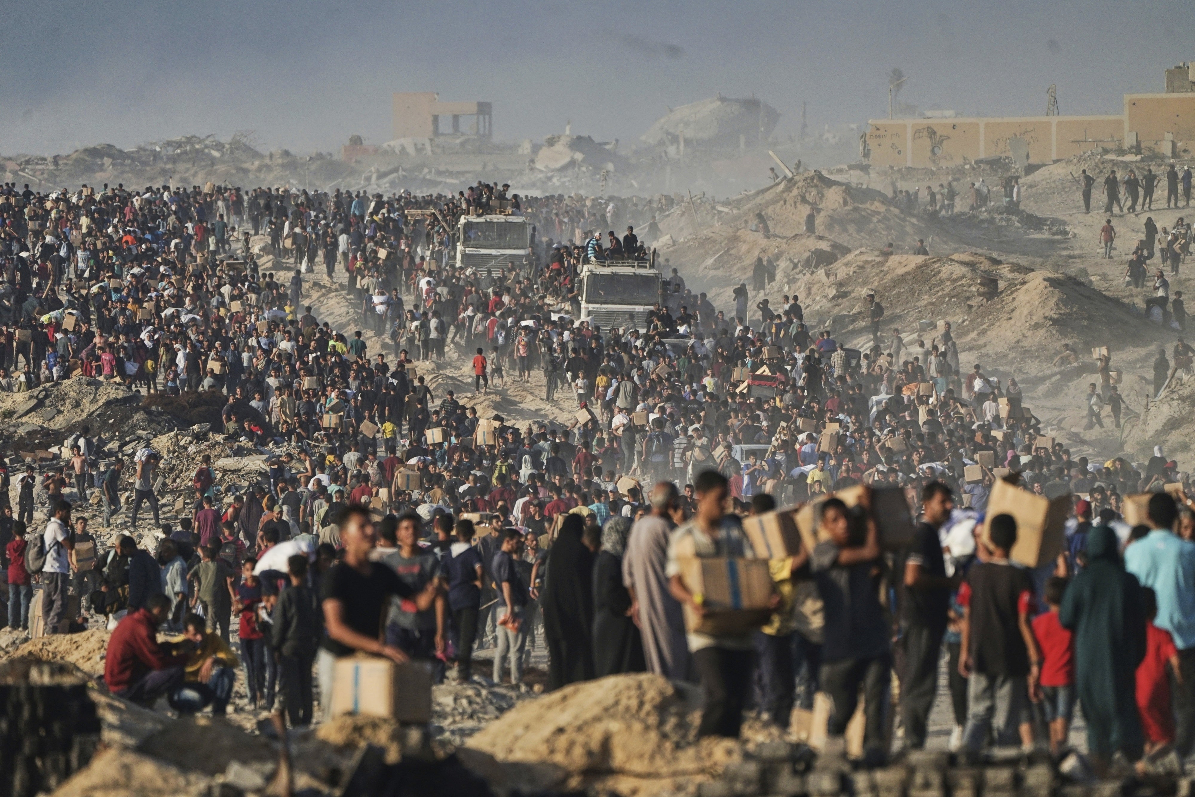  Palestinians carry food aid from a World Food Program convoy that was heading to Gaza City in the northern Gaza Strip, June 16, 2025. 