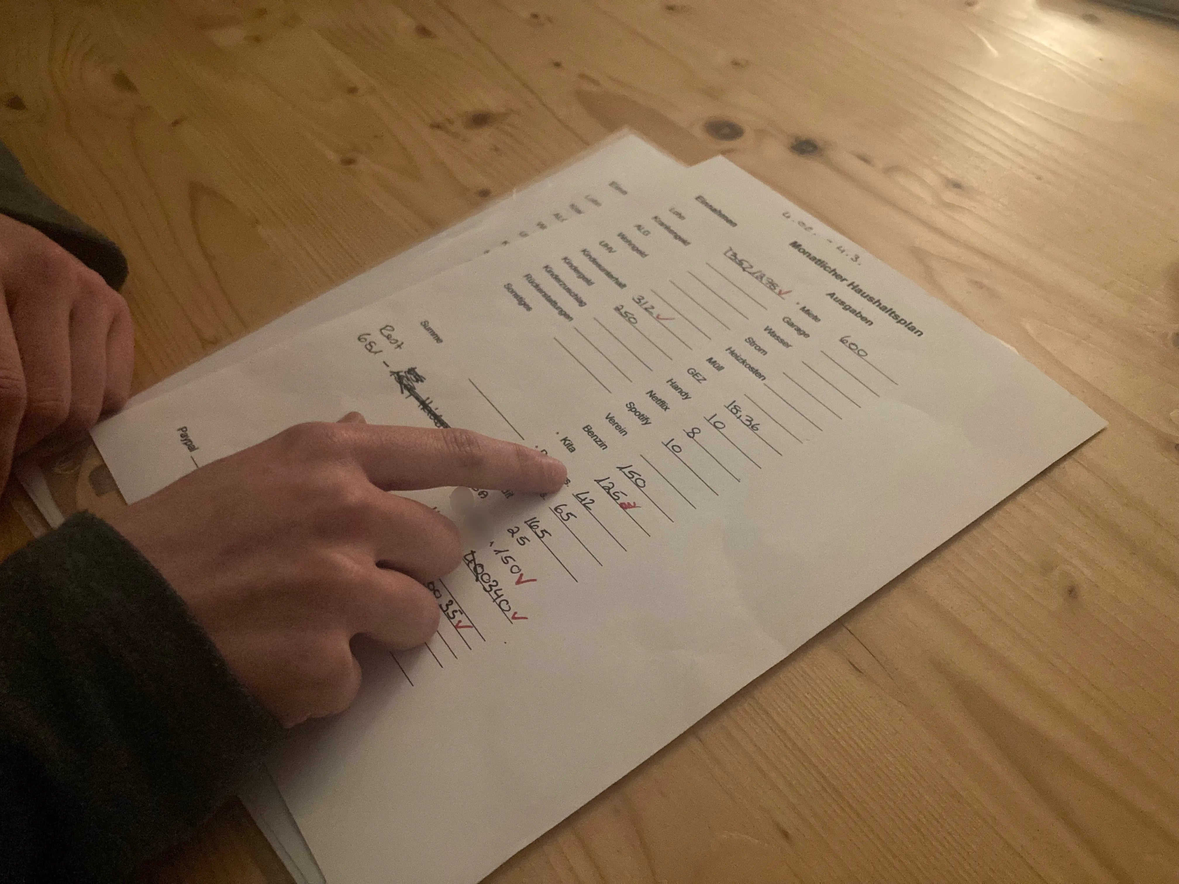 ine alleinerziehende Mutter, die im Niedriglohnsektor arbeitet, zeigt Human Rights Watch ihr monatliches Haushaltsbudget, während eines Interviews, Baden-Württemberg, Februar 2023