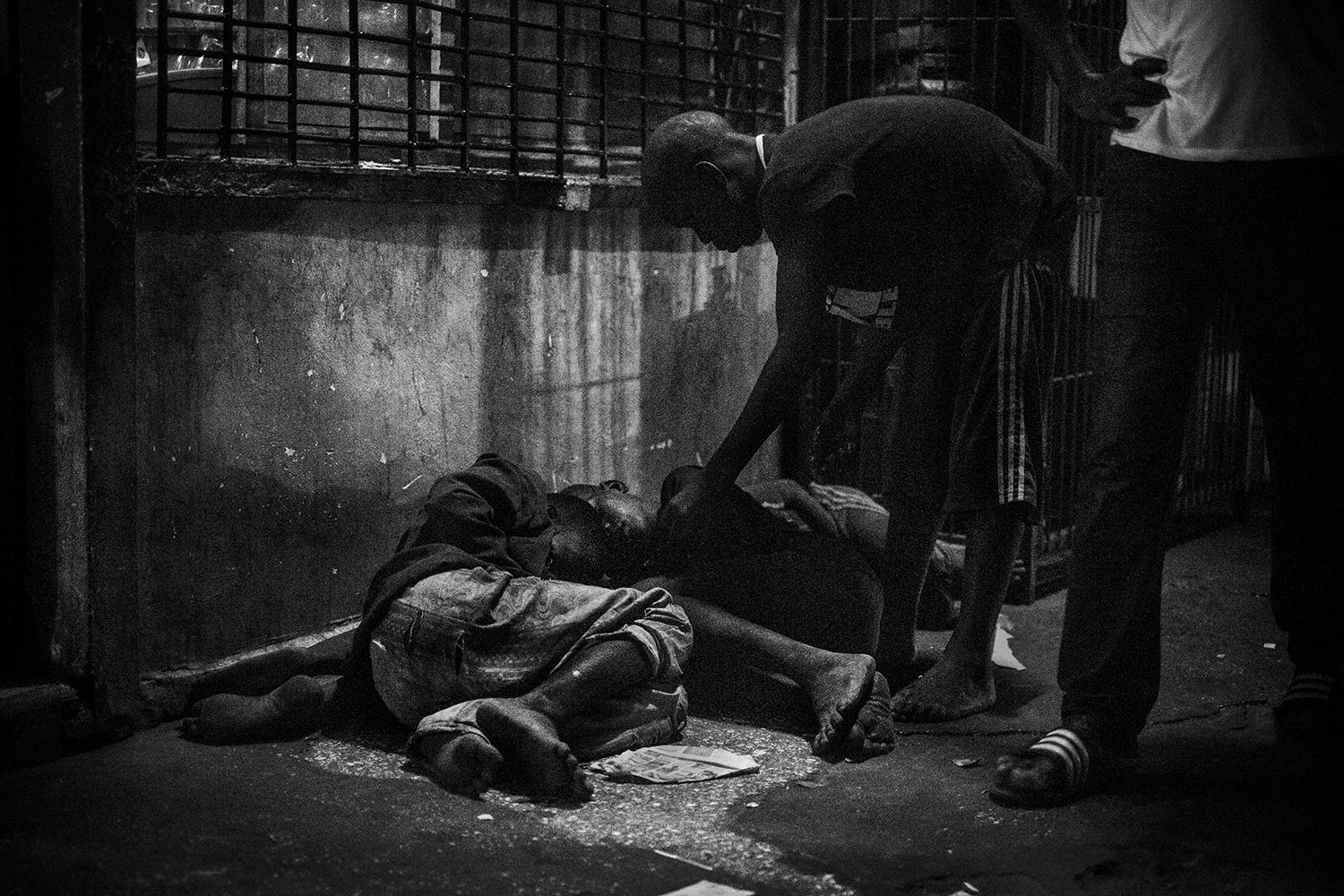 A talibé checks on other talibés sleeping in a street of Saint-Louis, Senegal, in May 2015. Many talibé children who run away from abusive Quranic schools sleep on the streets in groups to protect themselves. 