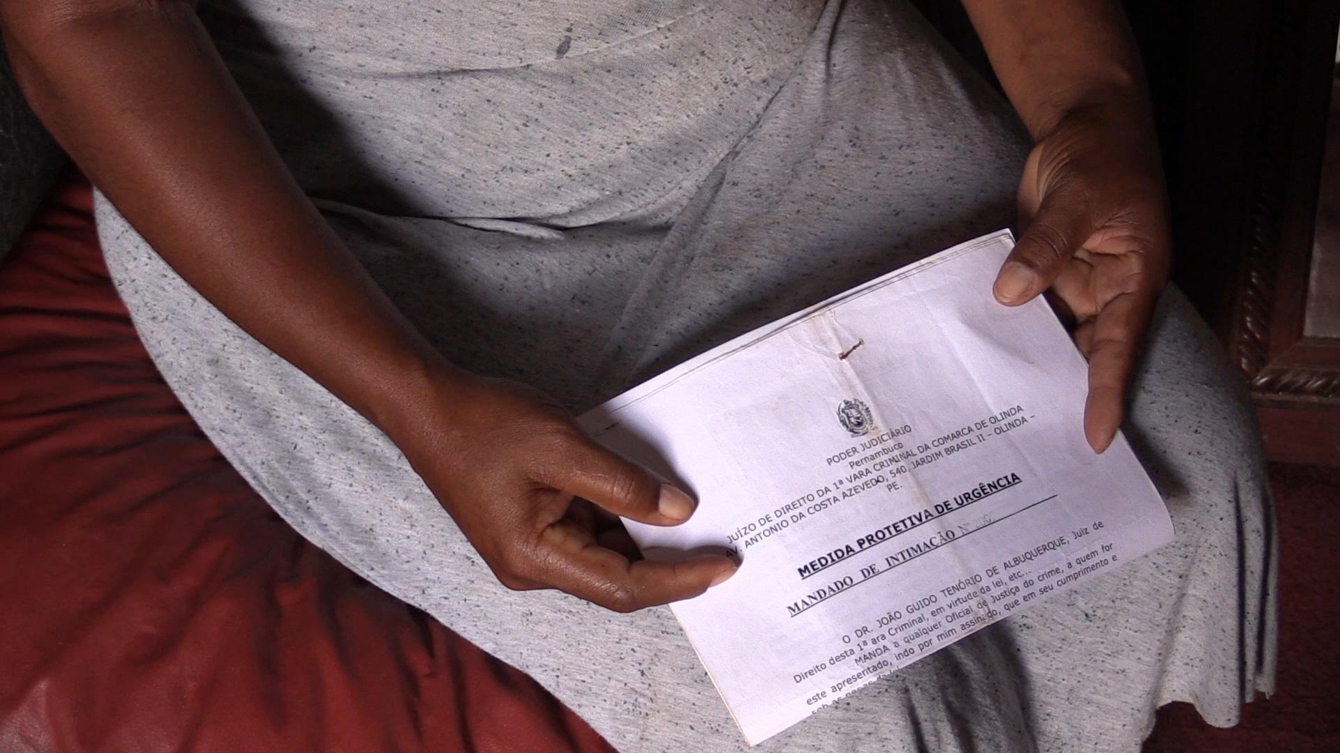 "Rita", a woman victim of domestic violence, holding a protective order issued by a judge in Pernambuco. October 2016.