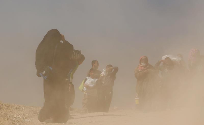 نازحون عراقيون فارون من بيوتهم أثناء قتال القوات العراقية مع مقاتلي "الدولة الإسلامية" في غرب الموصل، العراق، 6 مارس/ آذار 2017. 