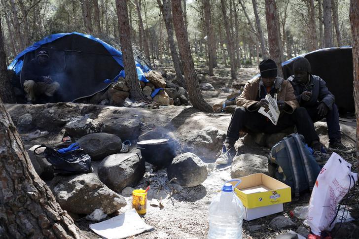 migrants sitting outside tent by morocco border