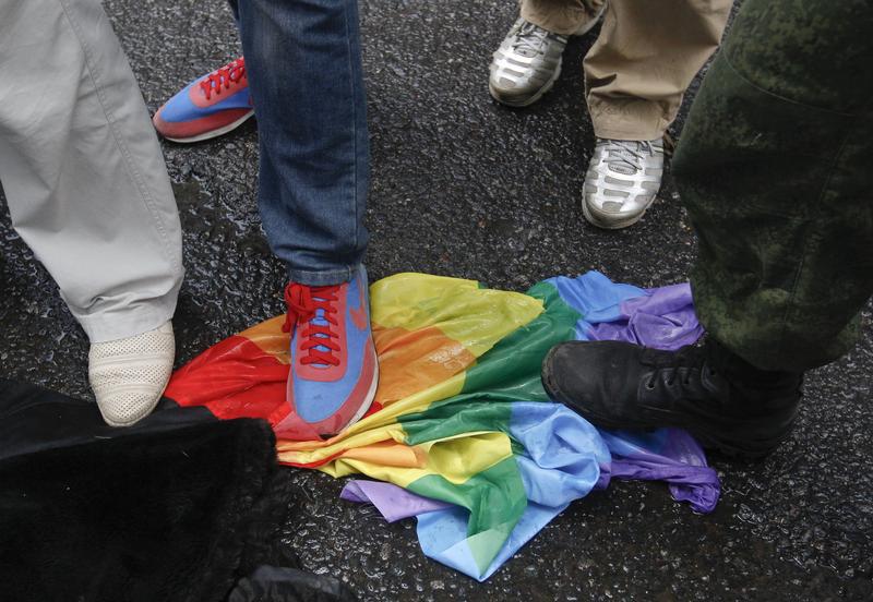 Anti-gay rights activists stand on a rainbow flag during a protest by gay rights activists demonstrating against a proposed new law termed by the State Duma, the lower house of Parliament, as "against advocating the rejection of traditional family values"