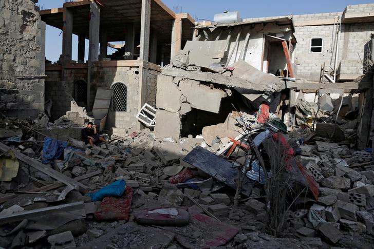 A man sits on the rubble of a house of his relatives, destroyed by a Saudi-led coalition airstrike in Sanaa, Yemen, June 9, 2017. 