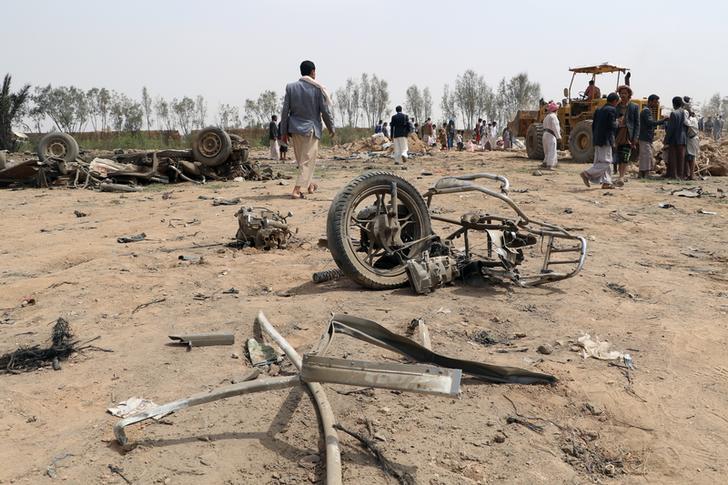 People stand at the site of a Saudi-led air strike on an outskirt of the northwestern city of Saada, Yemen, August 4, 2017. 