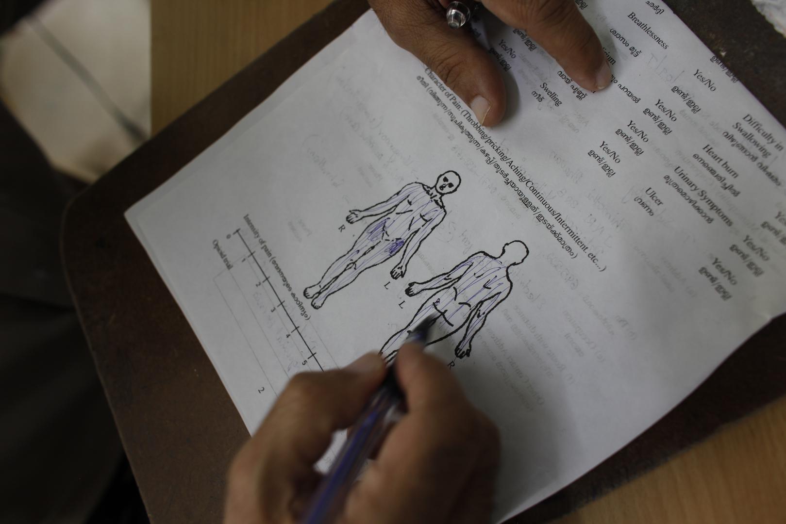 A palliative care physician assesses a patient’s pain.